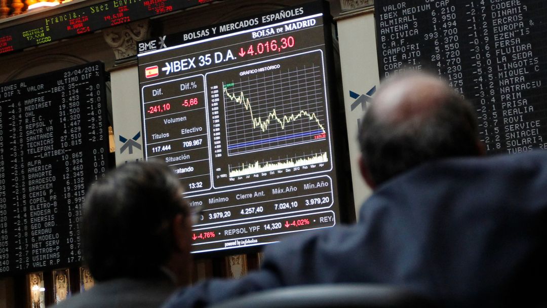 Dos traders observan la marcha de la cotización del Ibex 35 en la Bolsa de Madrid