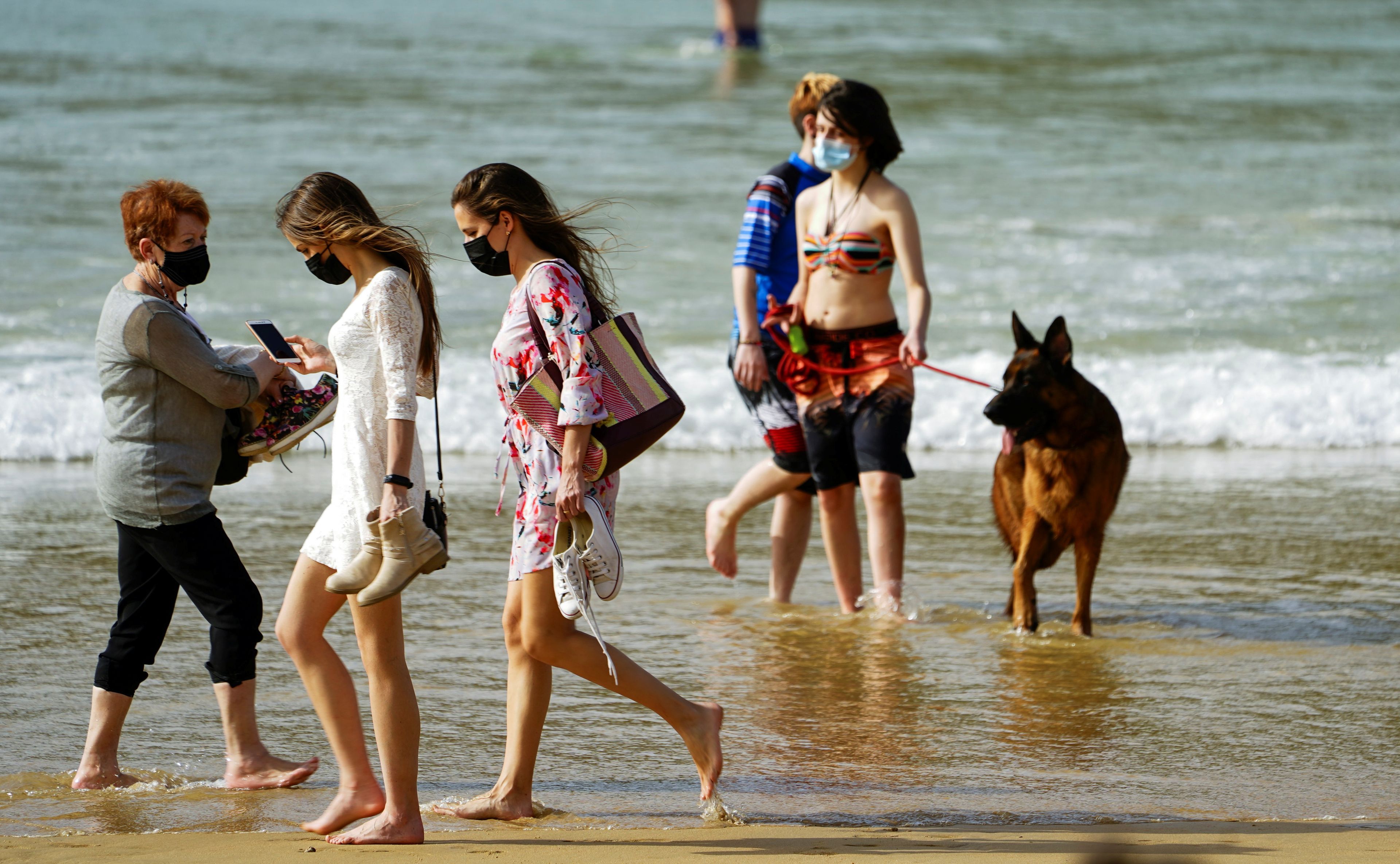 Gente pasea por la playa en medio de la pandemia en España.