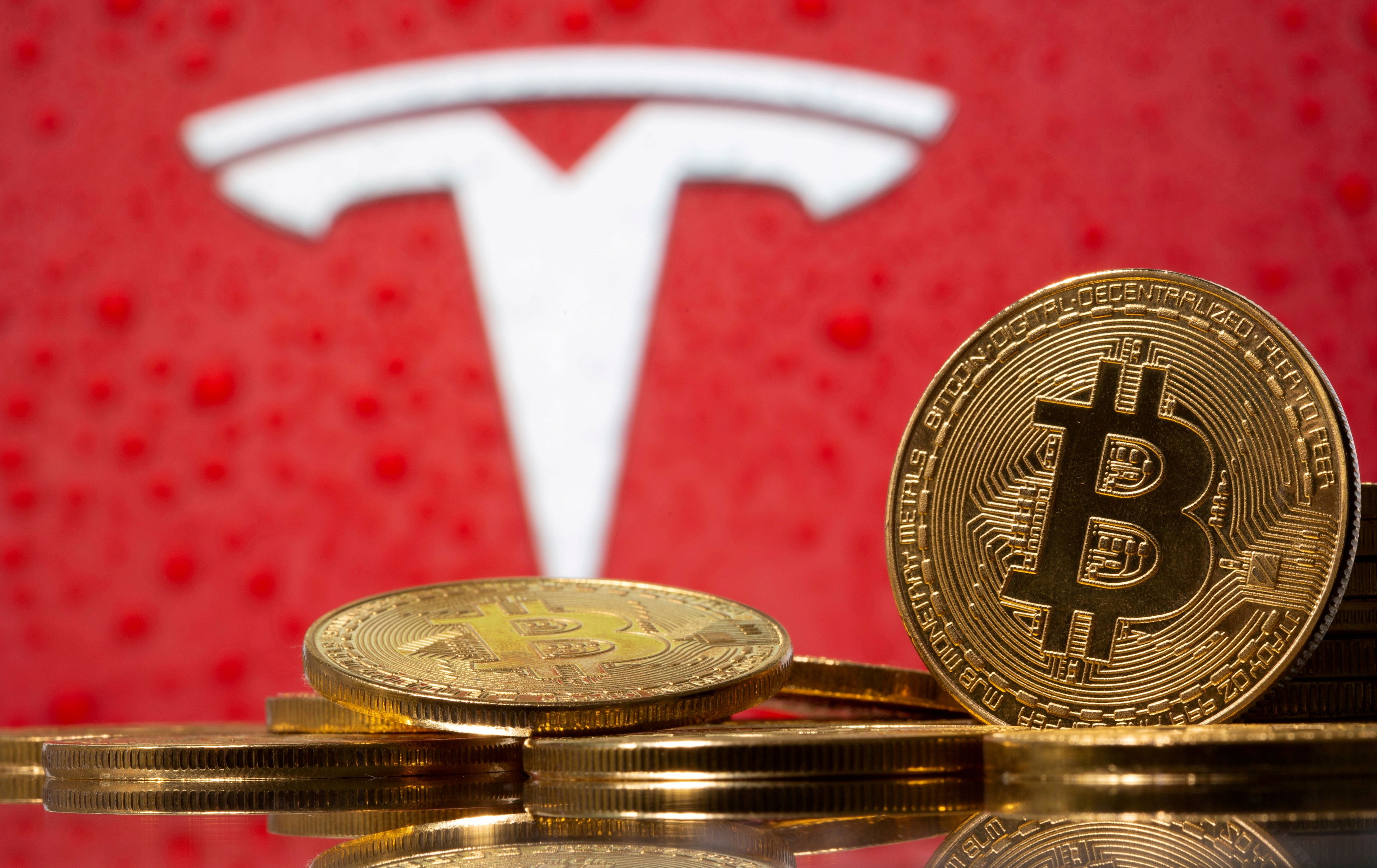 Logotipo de Tesla con monedas con el símbolo del bitcoin.
