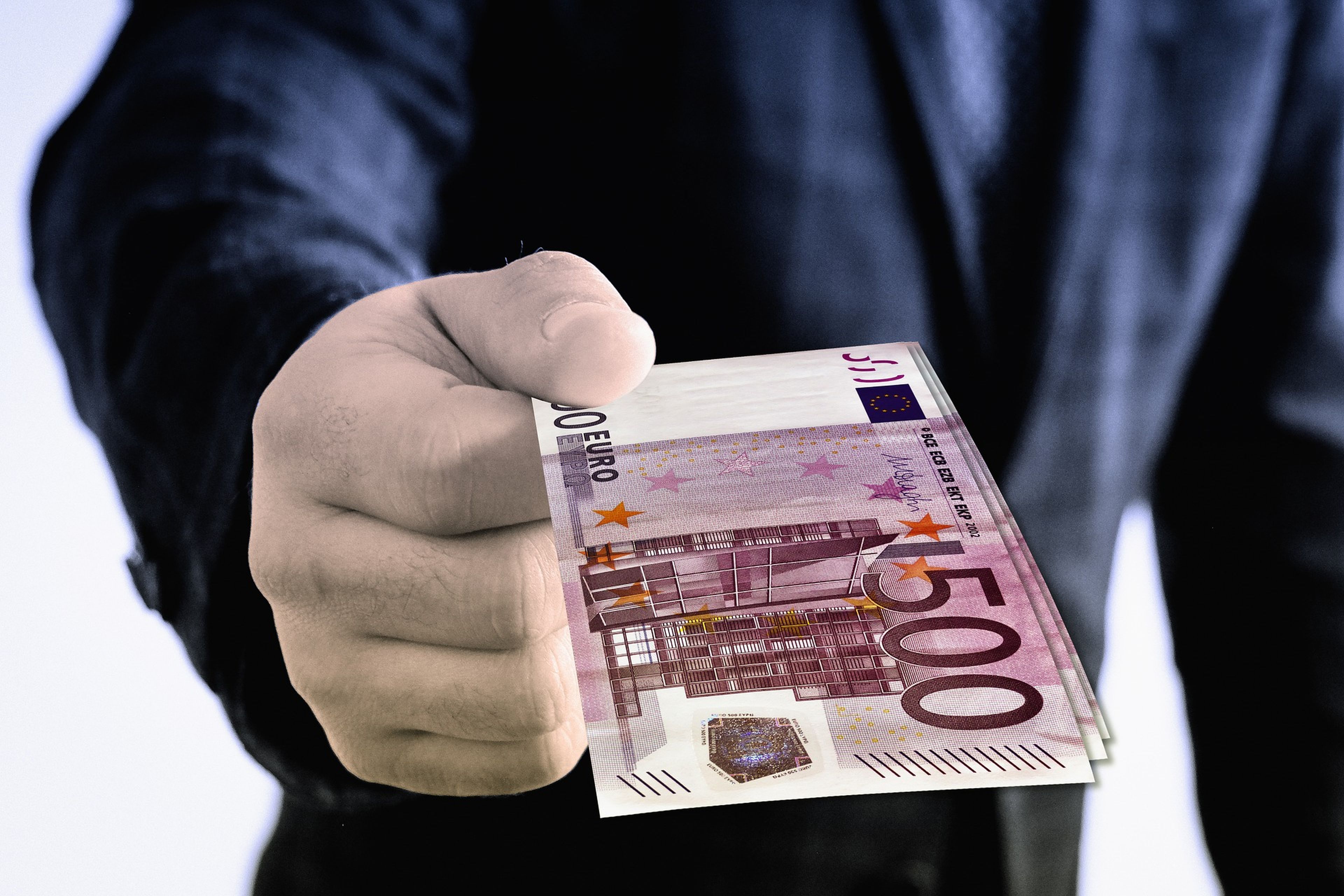 Una mano de hombre con un billete de 500 euros.
