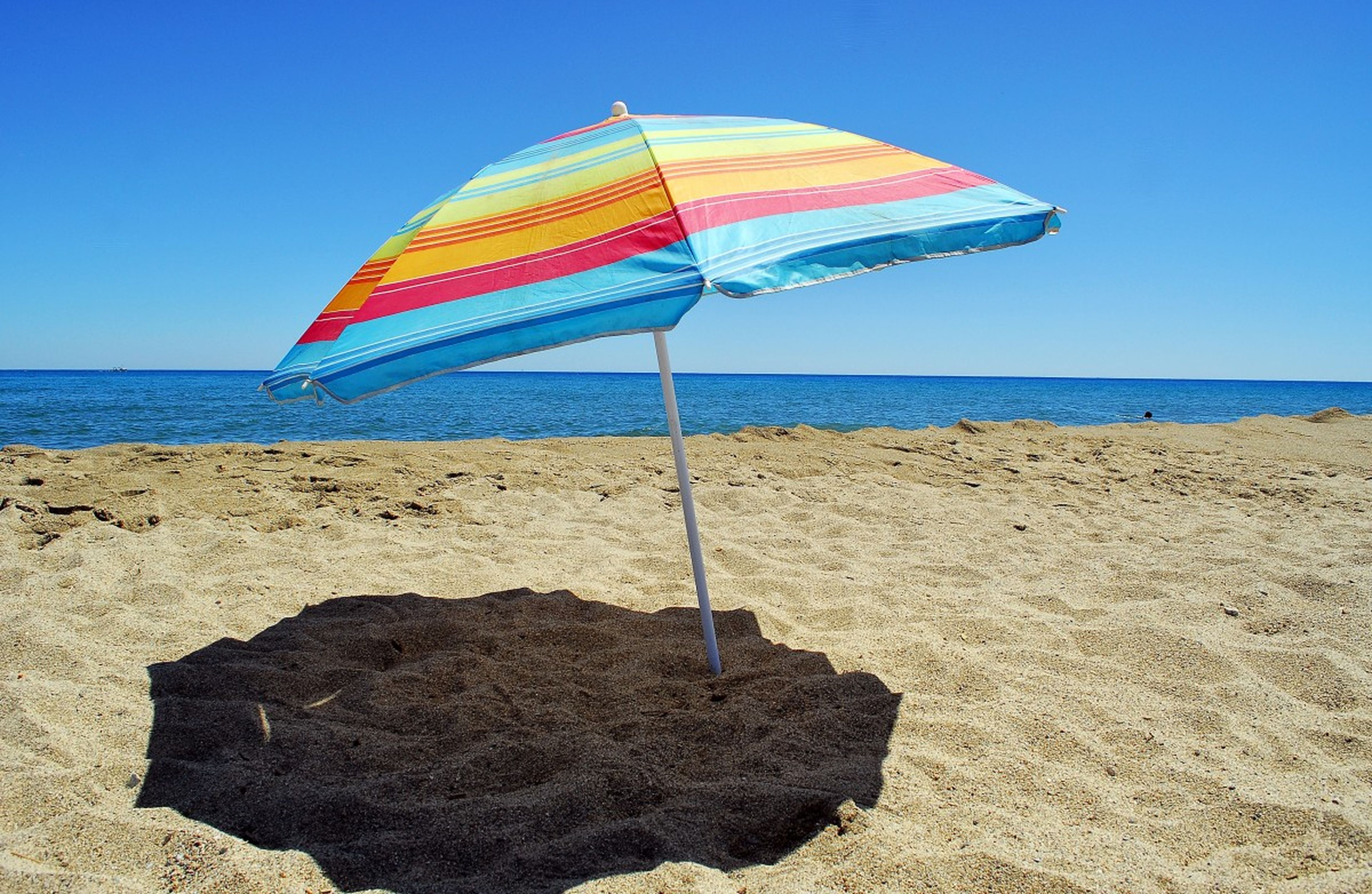 Una sombrilla en la arena de la playa