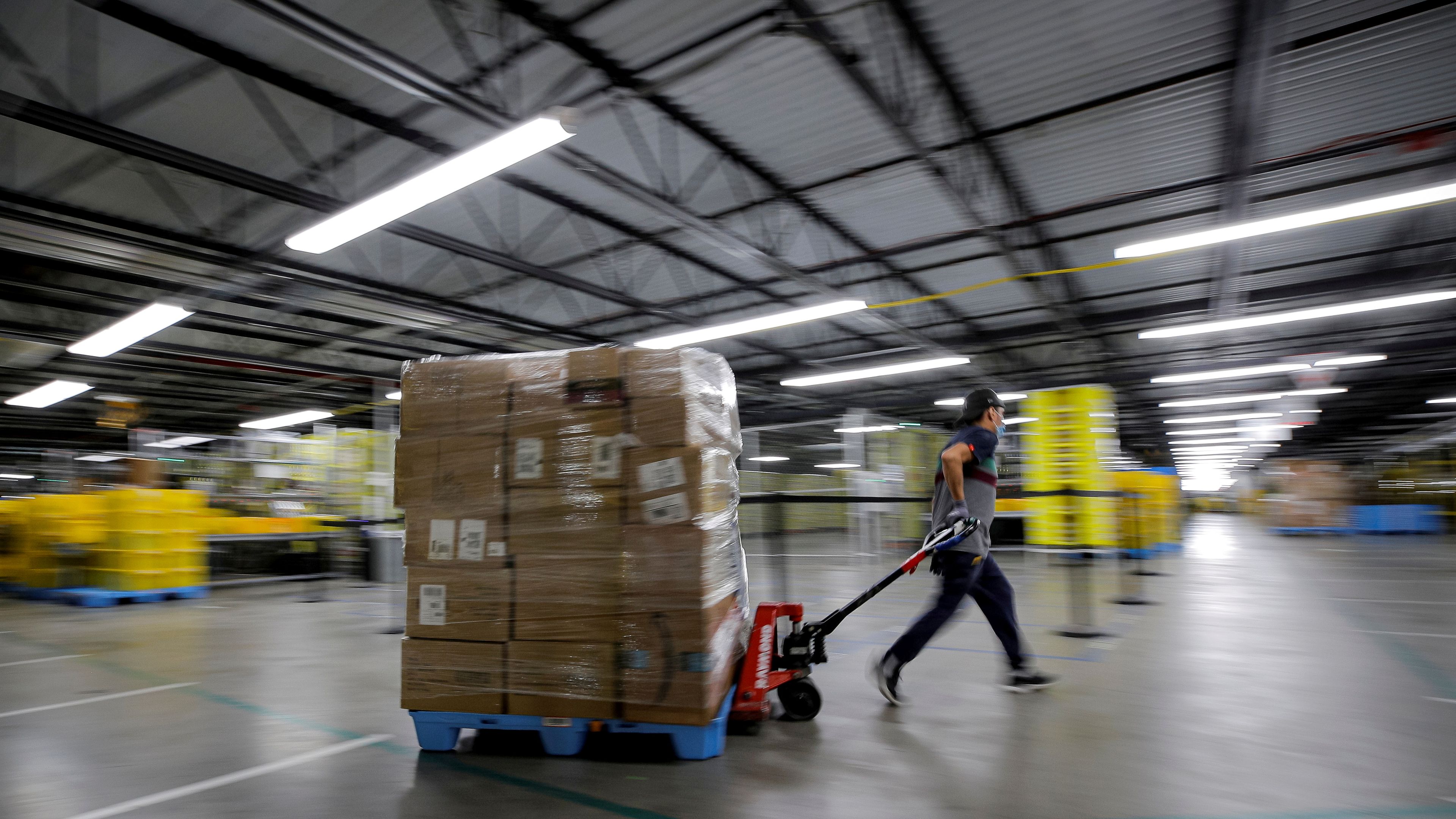 Un trabajador de Amazon corriendo por uno de sus almacenes.