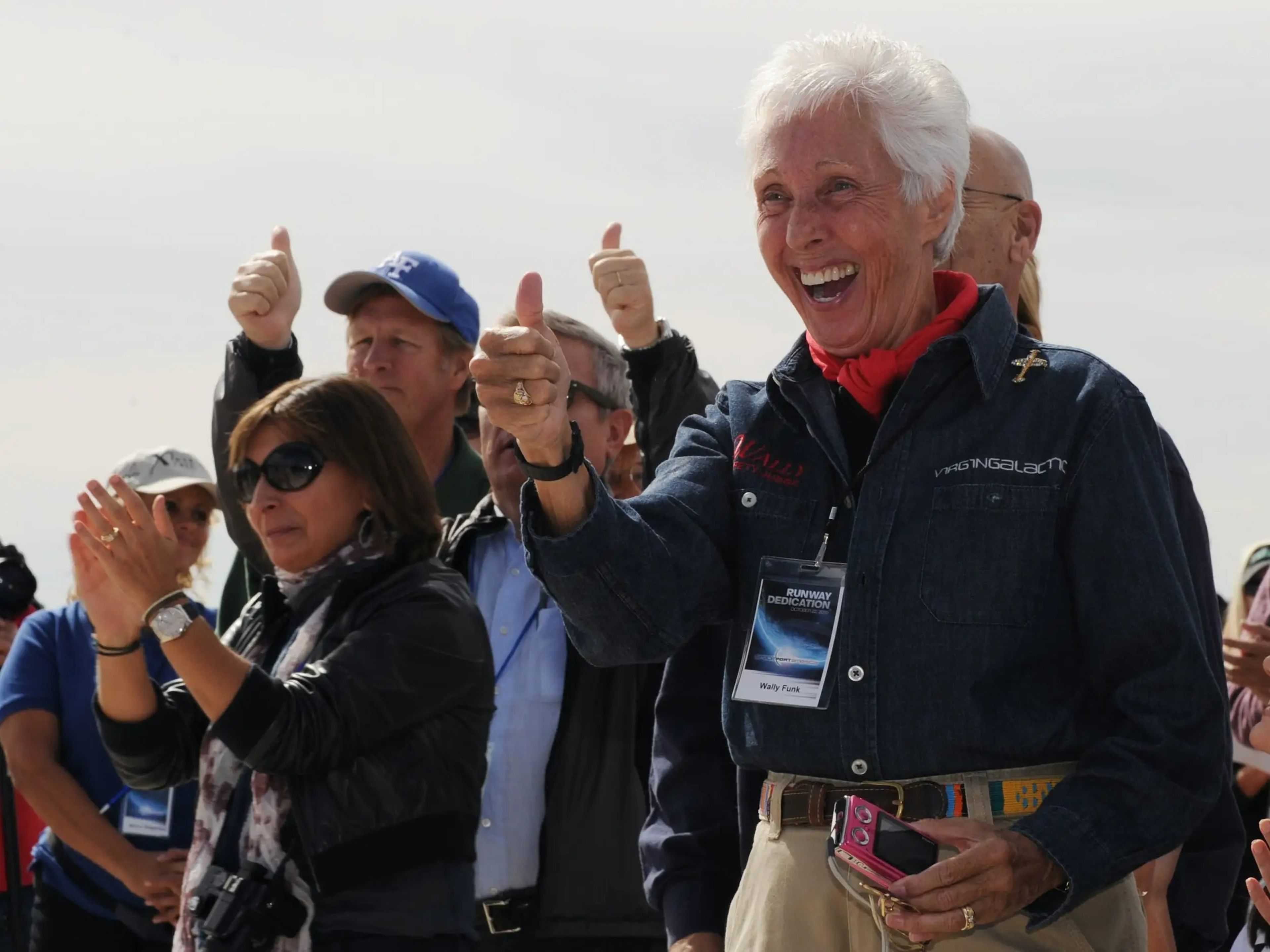 Aviator Wally Funk gives a thumbs up surrounded by other hopeful space tourists