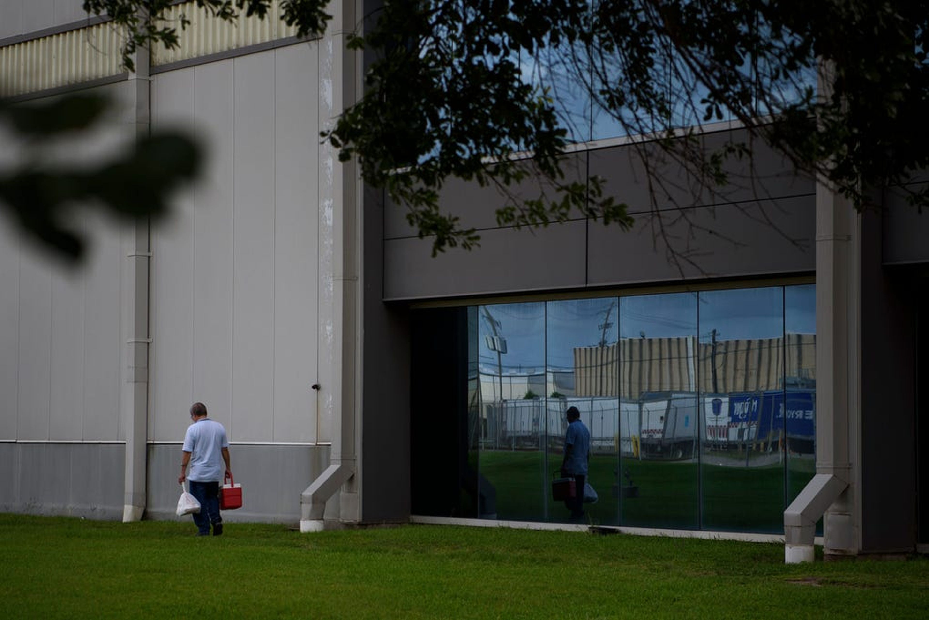 Una persona pasa delante de un almacén de CSAT Solutions en Houston (Texas)