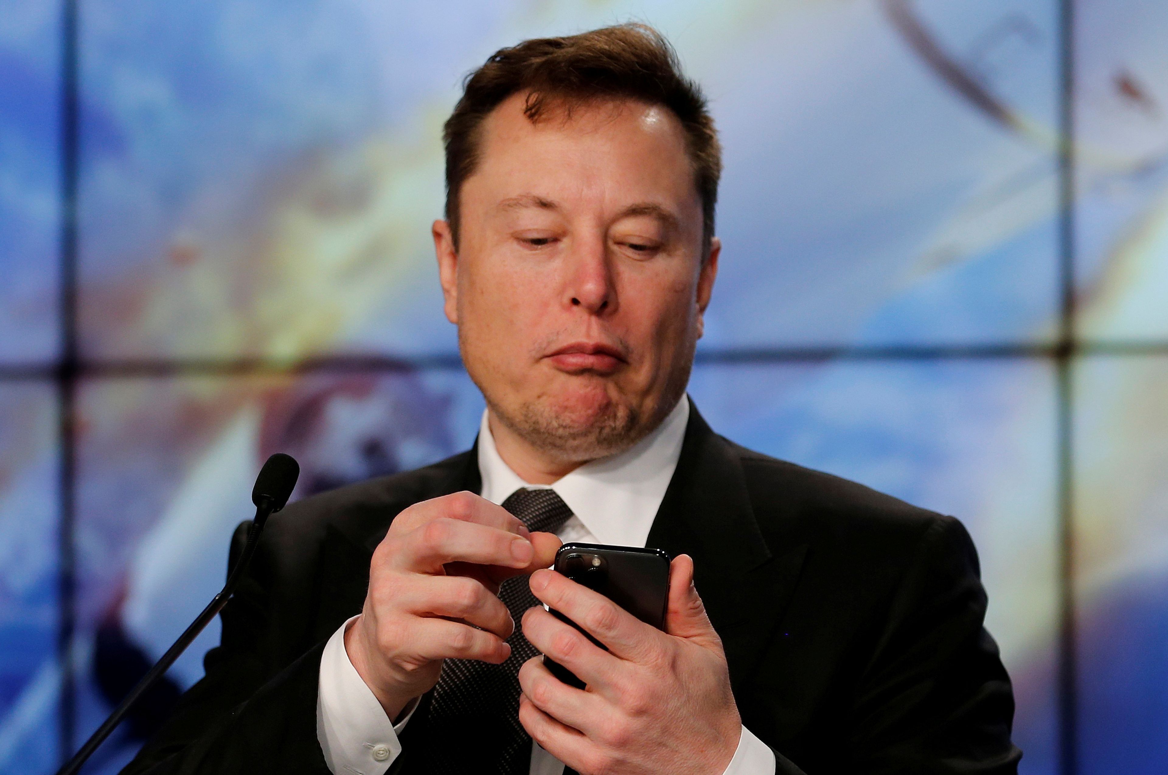 Elon Musk consultando su teléfono móvil