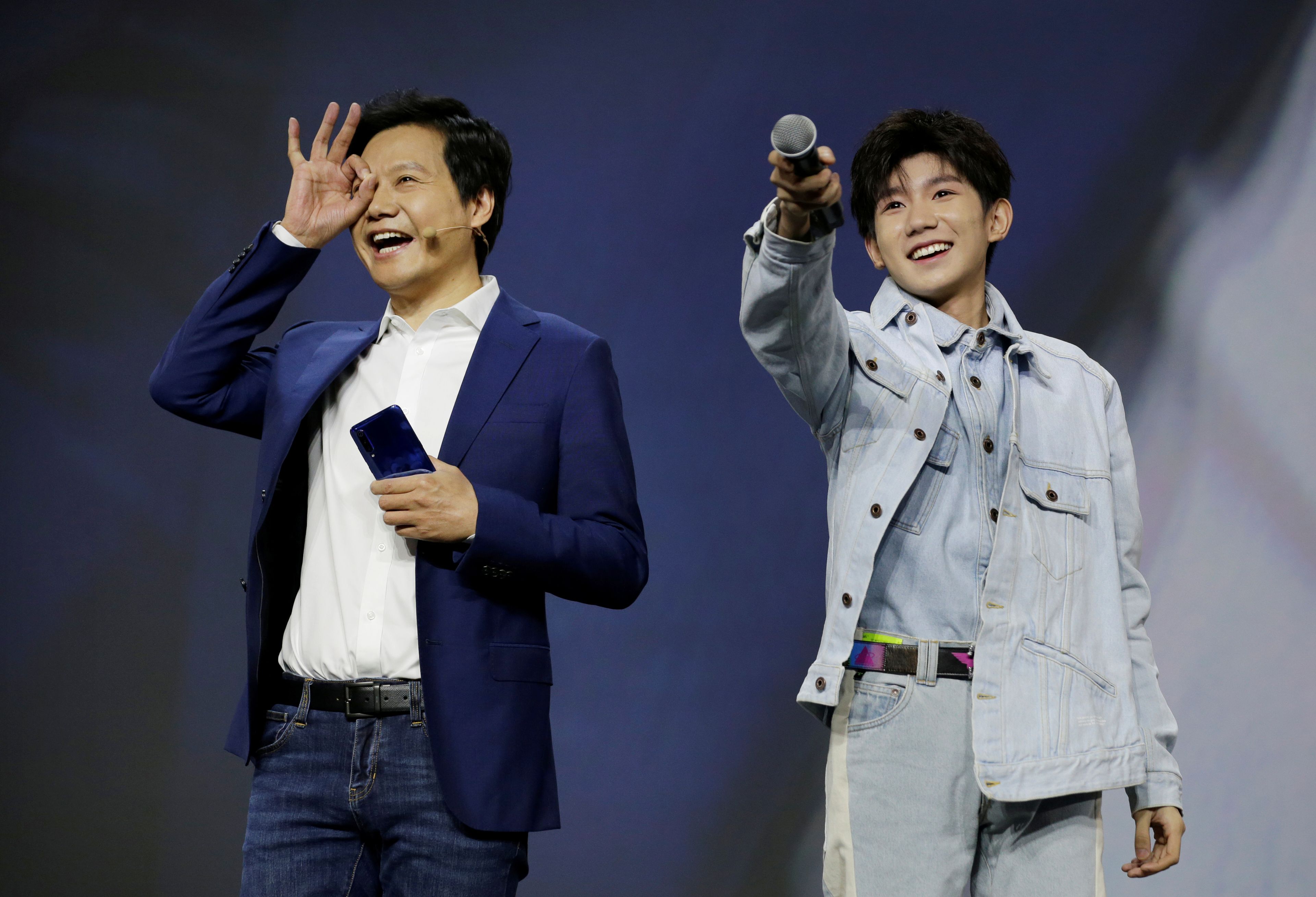 El fundador y CEO de Xiaomi, Lei Jun, y el cantante Wang Yuan, asisten a una ceremonia de lanzamiento del Xiaomi Mi 9 en Pekín en 2019.