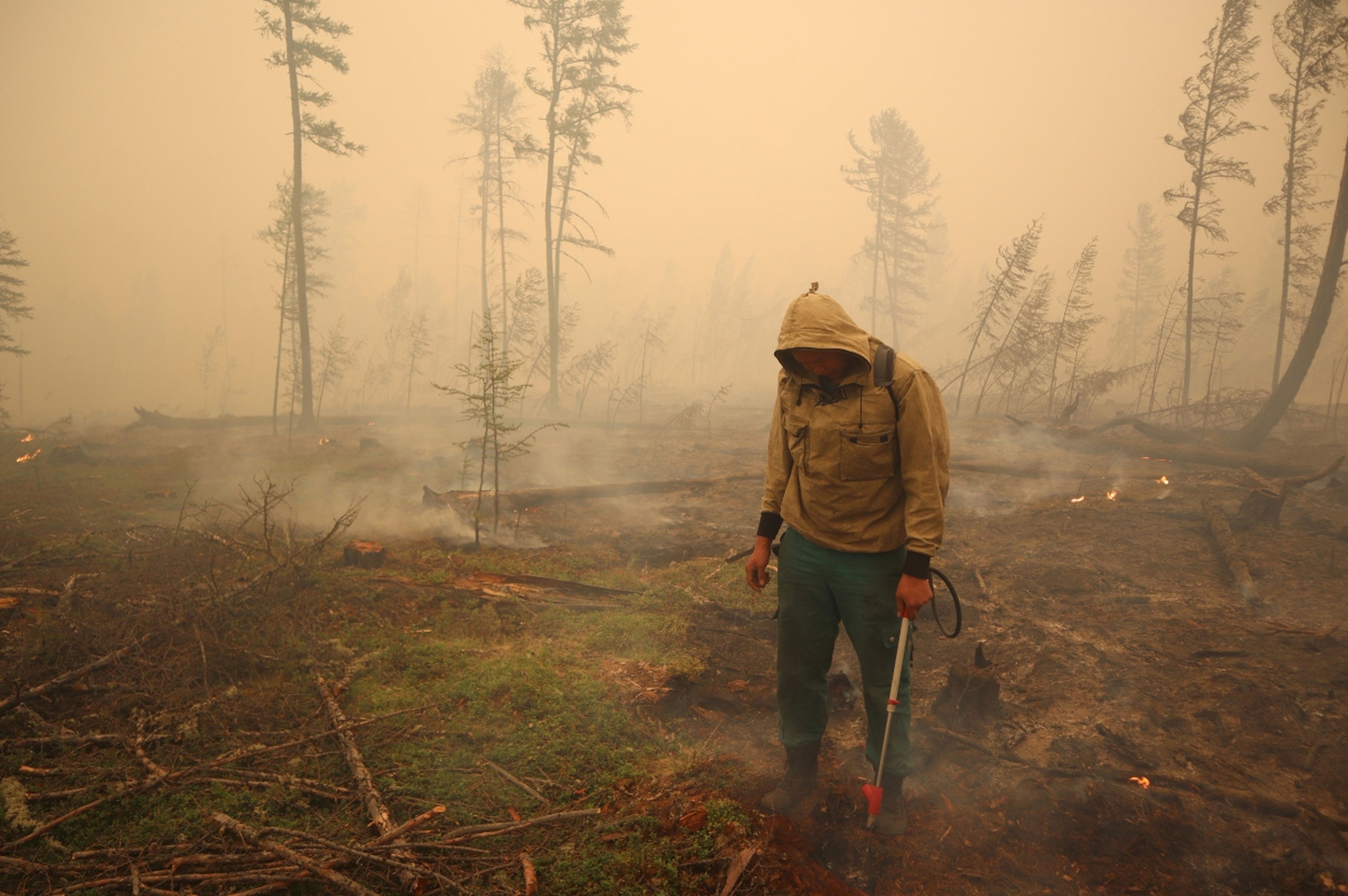 Un especialista del servicio local de protección forestal trabaja para extinguir un incendio forestal cerca del pueblo de Magaras en la región de Yakutia (Rusia) el 17 de julio de 2021.