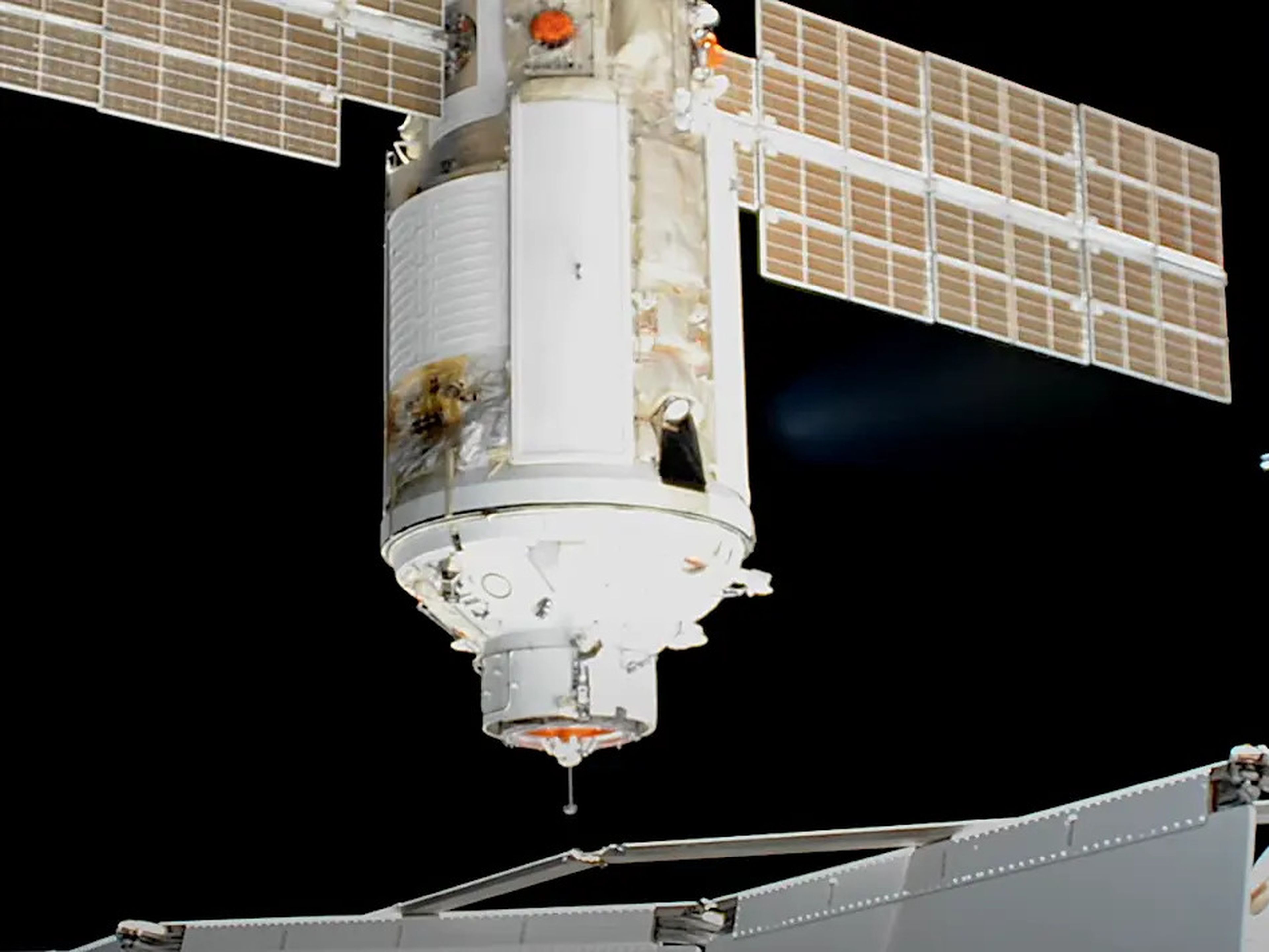 nauka module spaceship with solar array wings approaches international space station