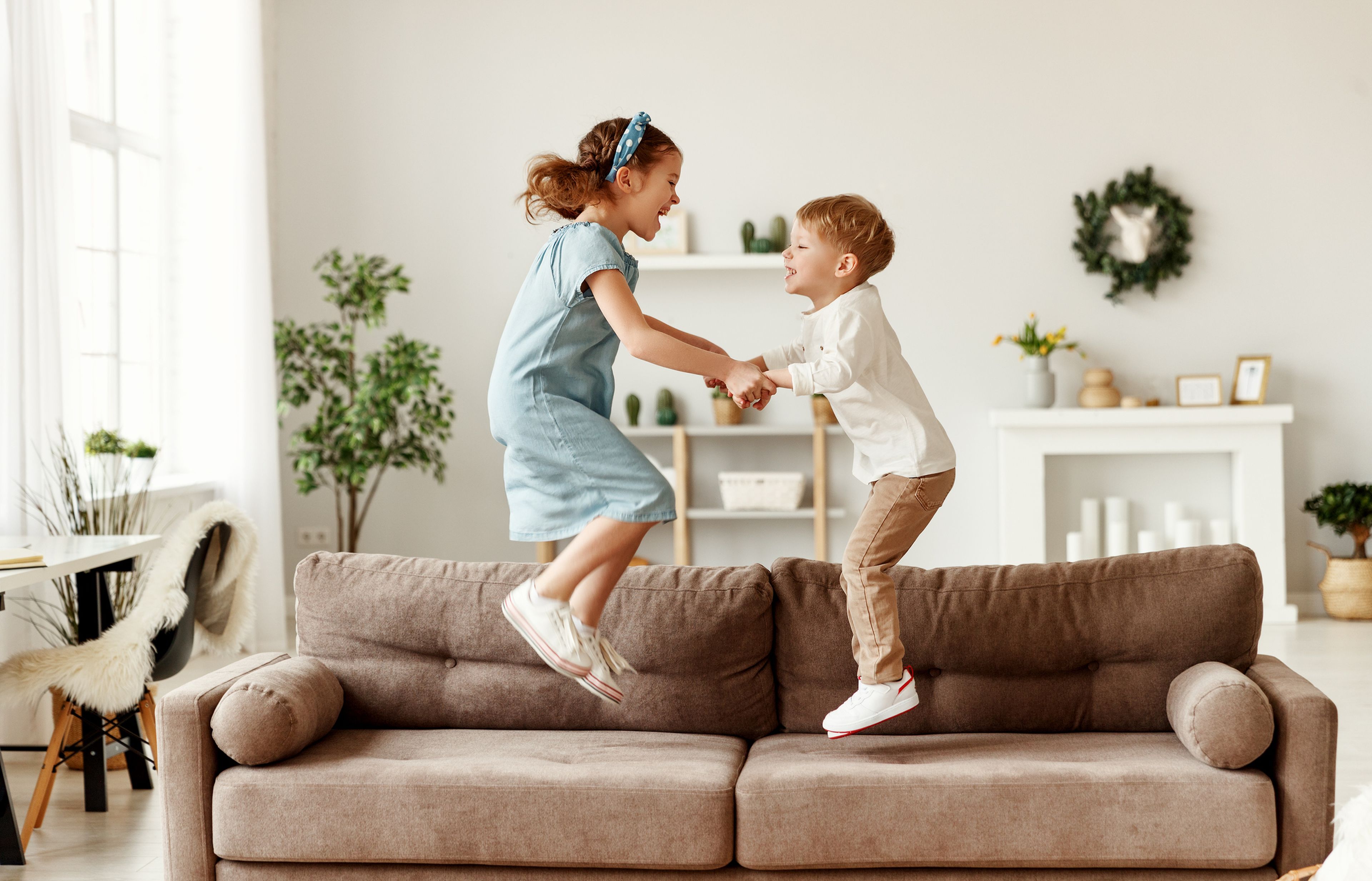 Niños saltando en el sofá
