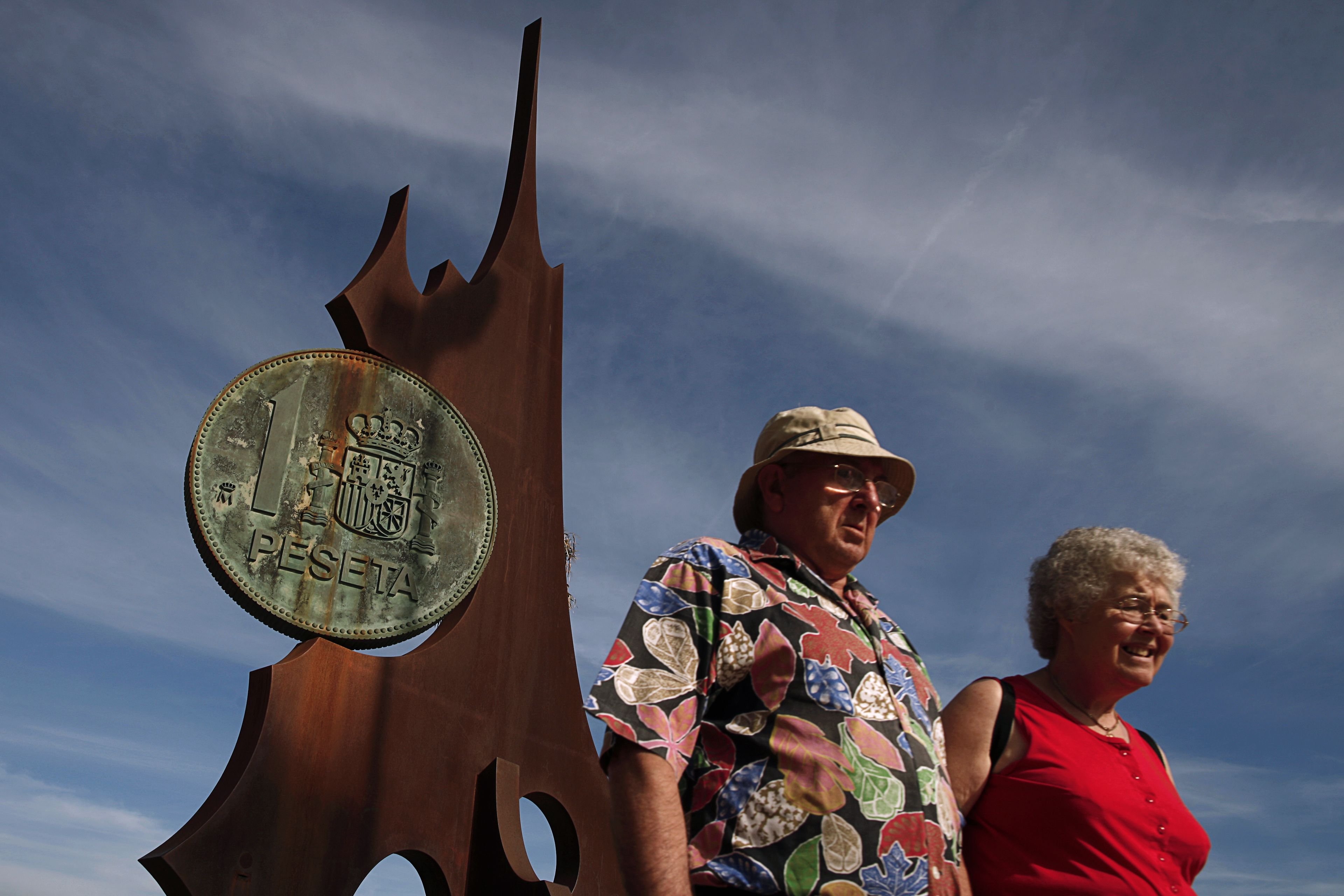 Una pareja delante de un monumento a la peseta