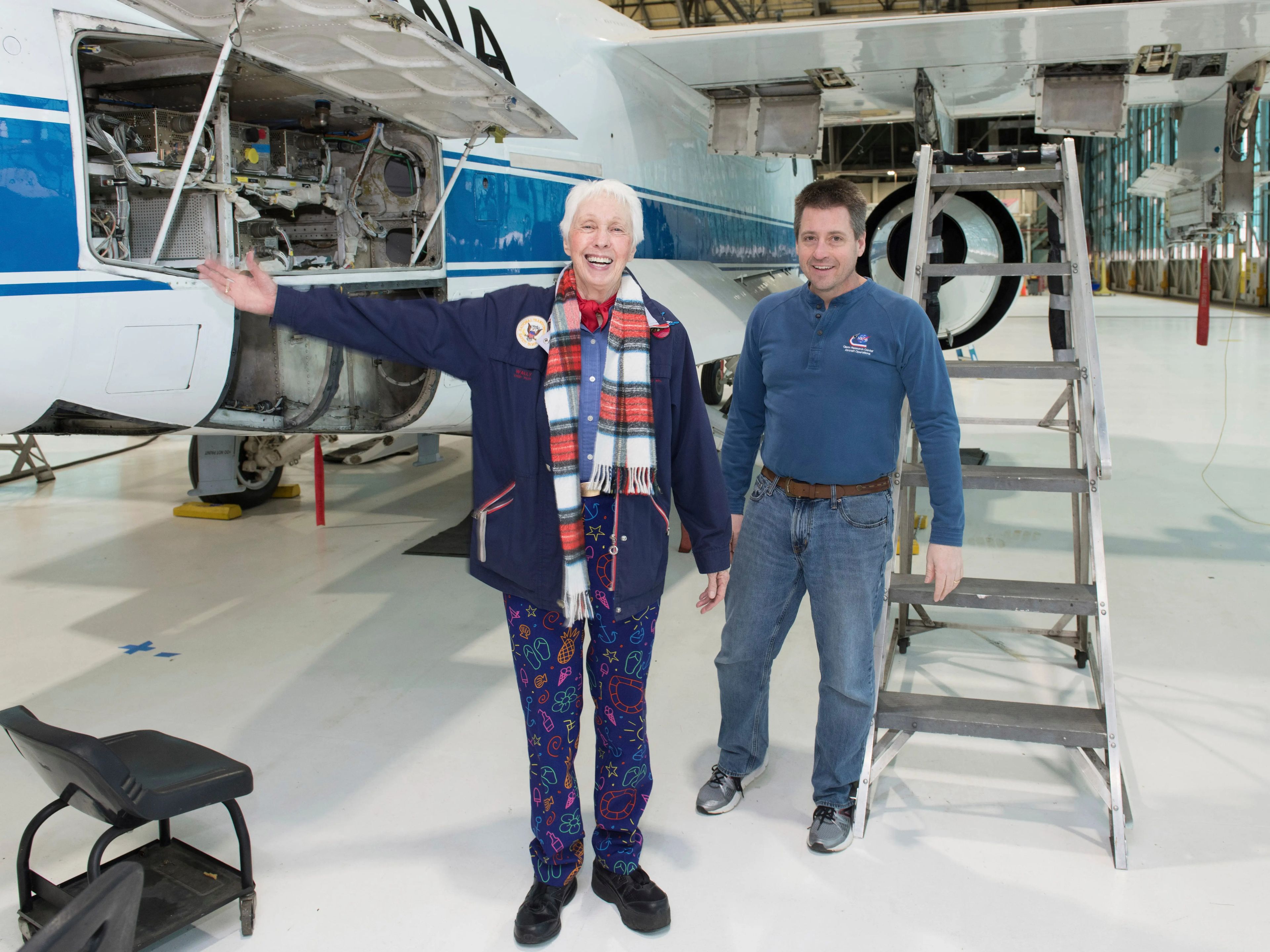 Wally Funk and a man stand near an airplane