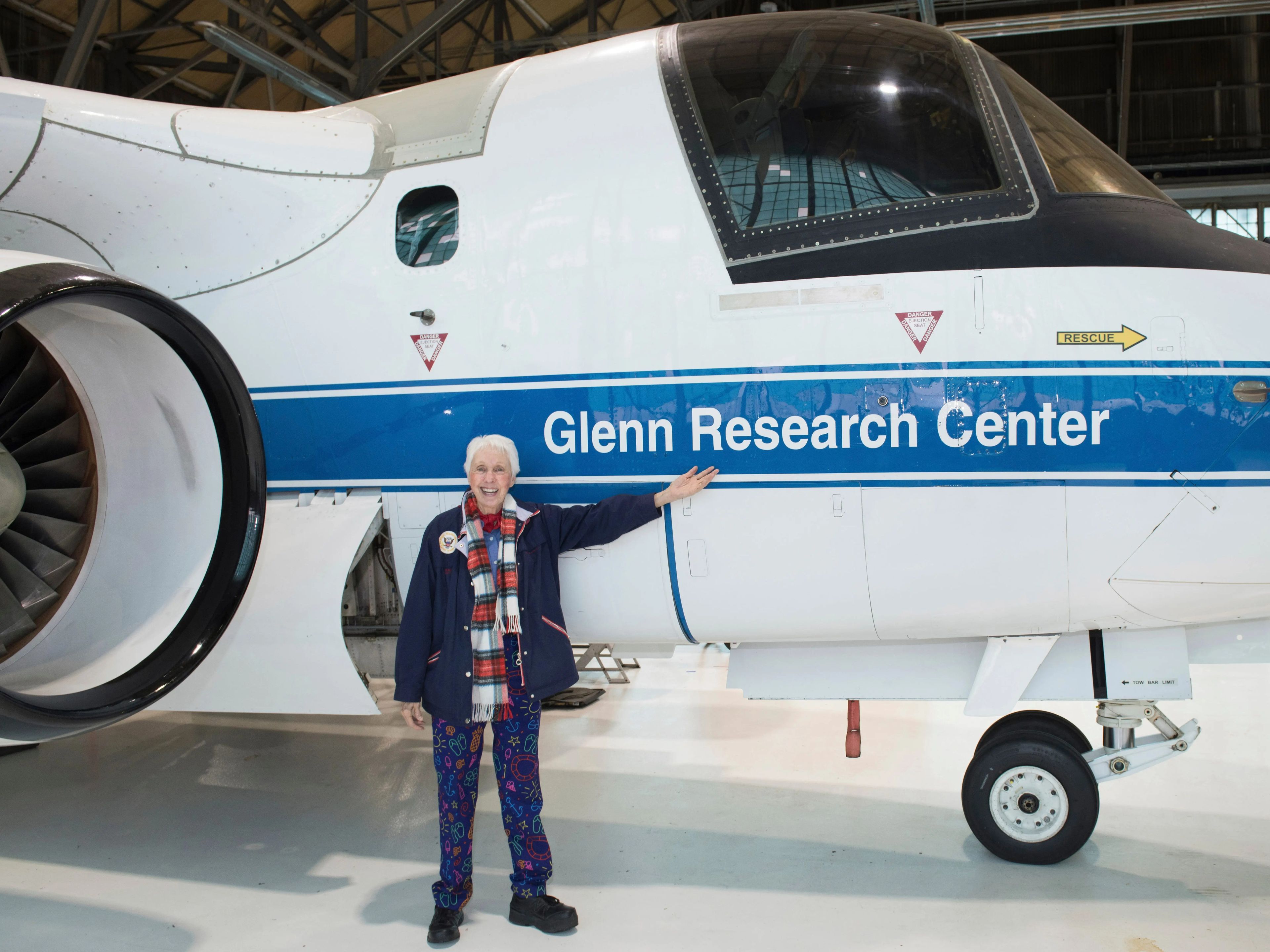 Wally Funk stands in front of a plane that reads Glenn Research Center