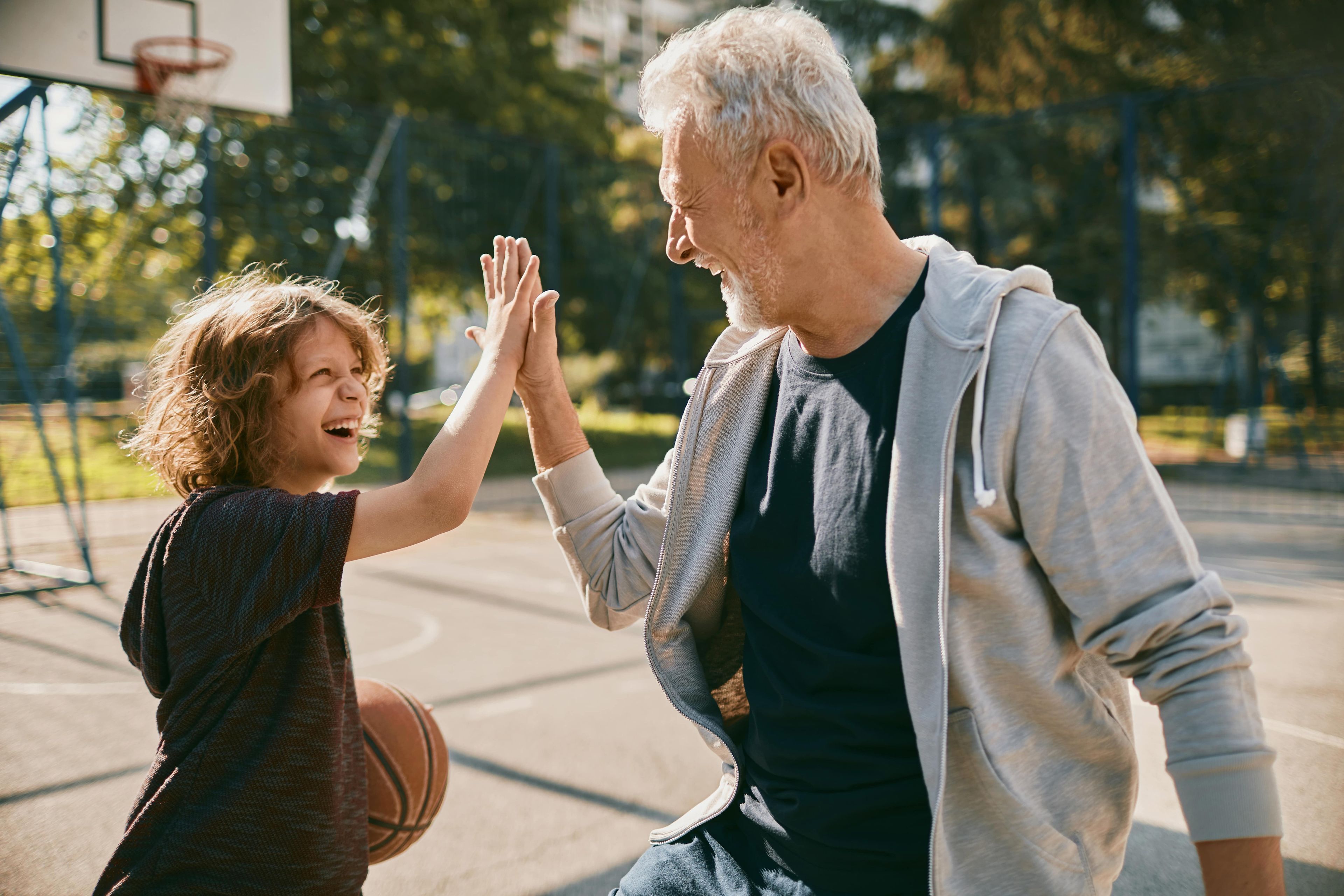 Abuelo jugando al baloncesto con su nieto