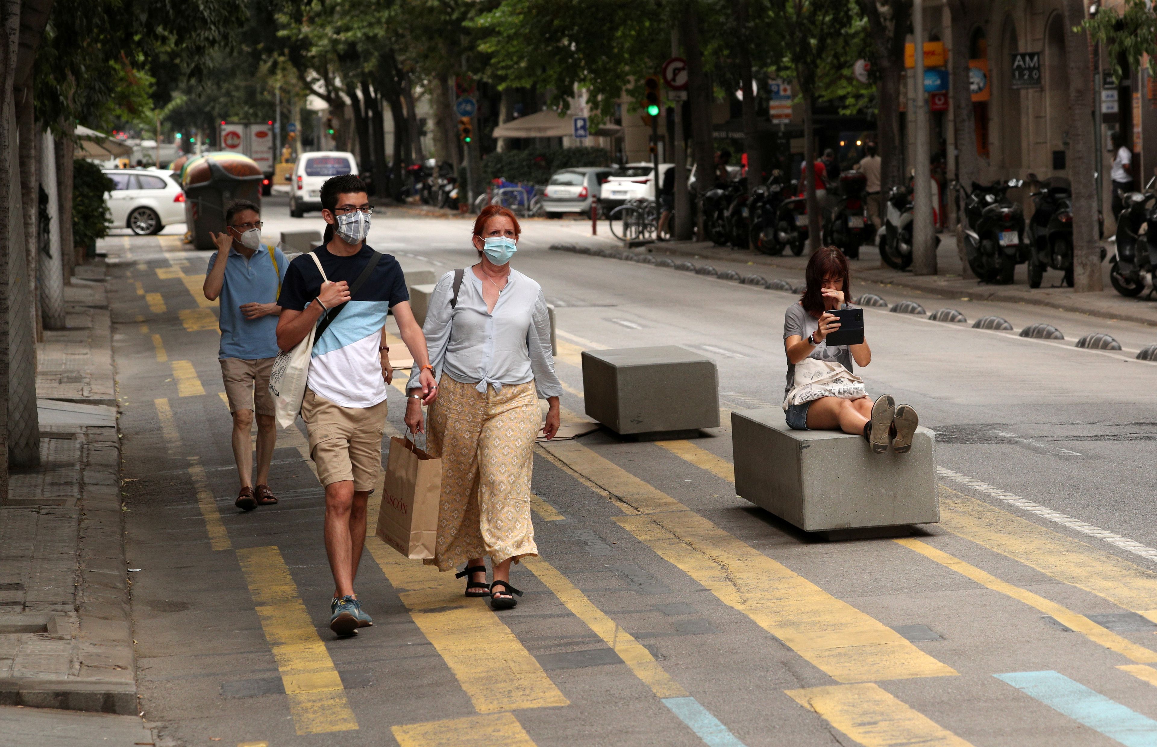 Gente por la calle en España con mascarilla.