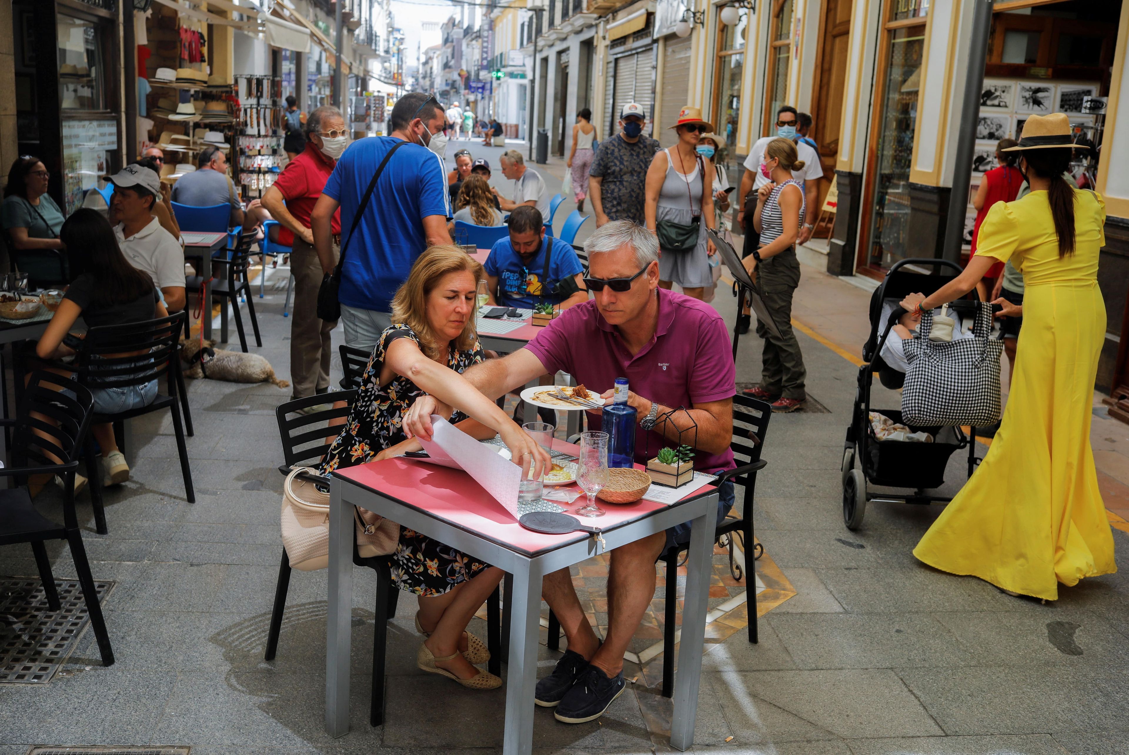 Gente comiendo en una terraza de un bar.
