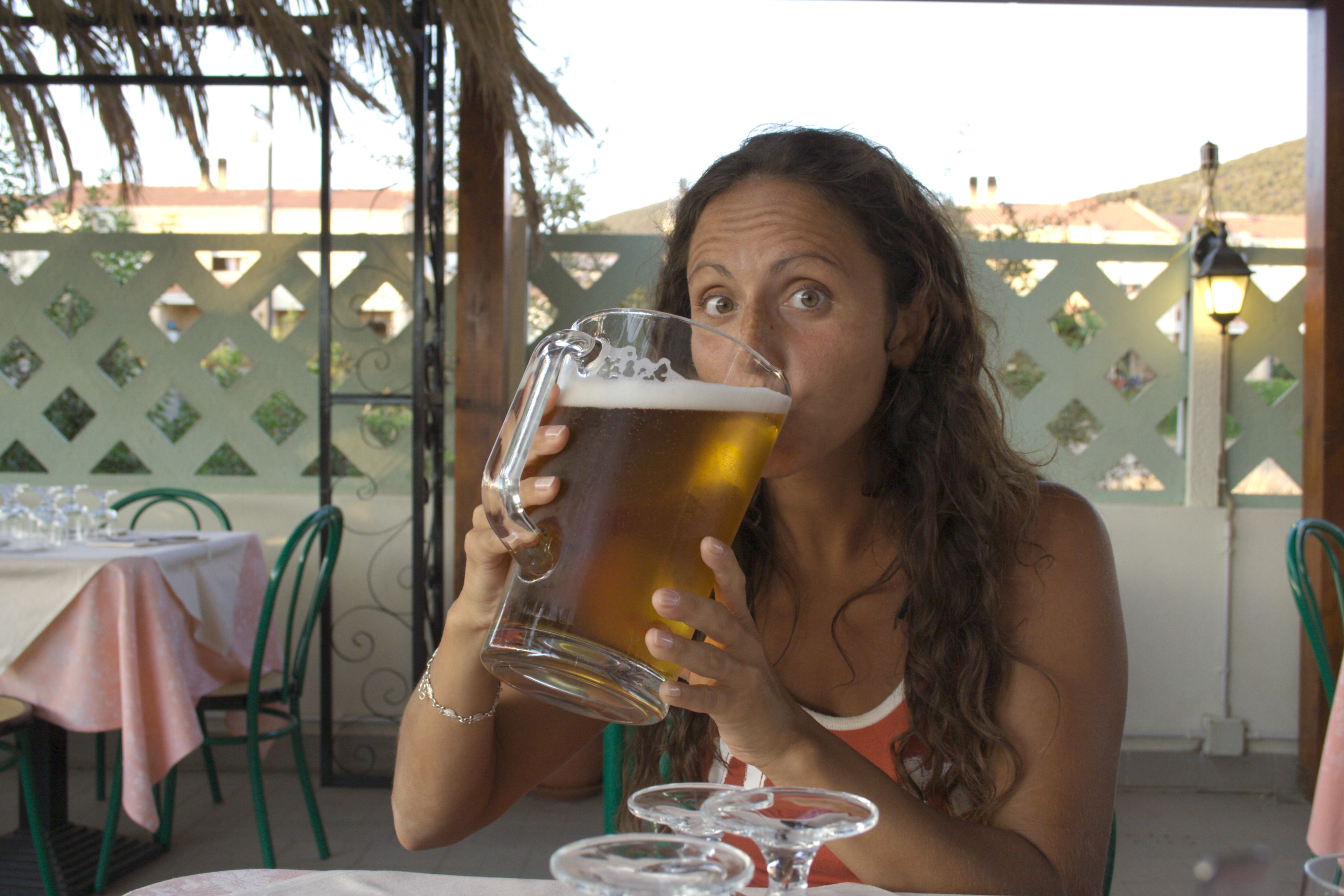 Mujer bebiendo una gran jarra de cerveza