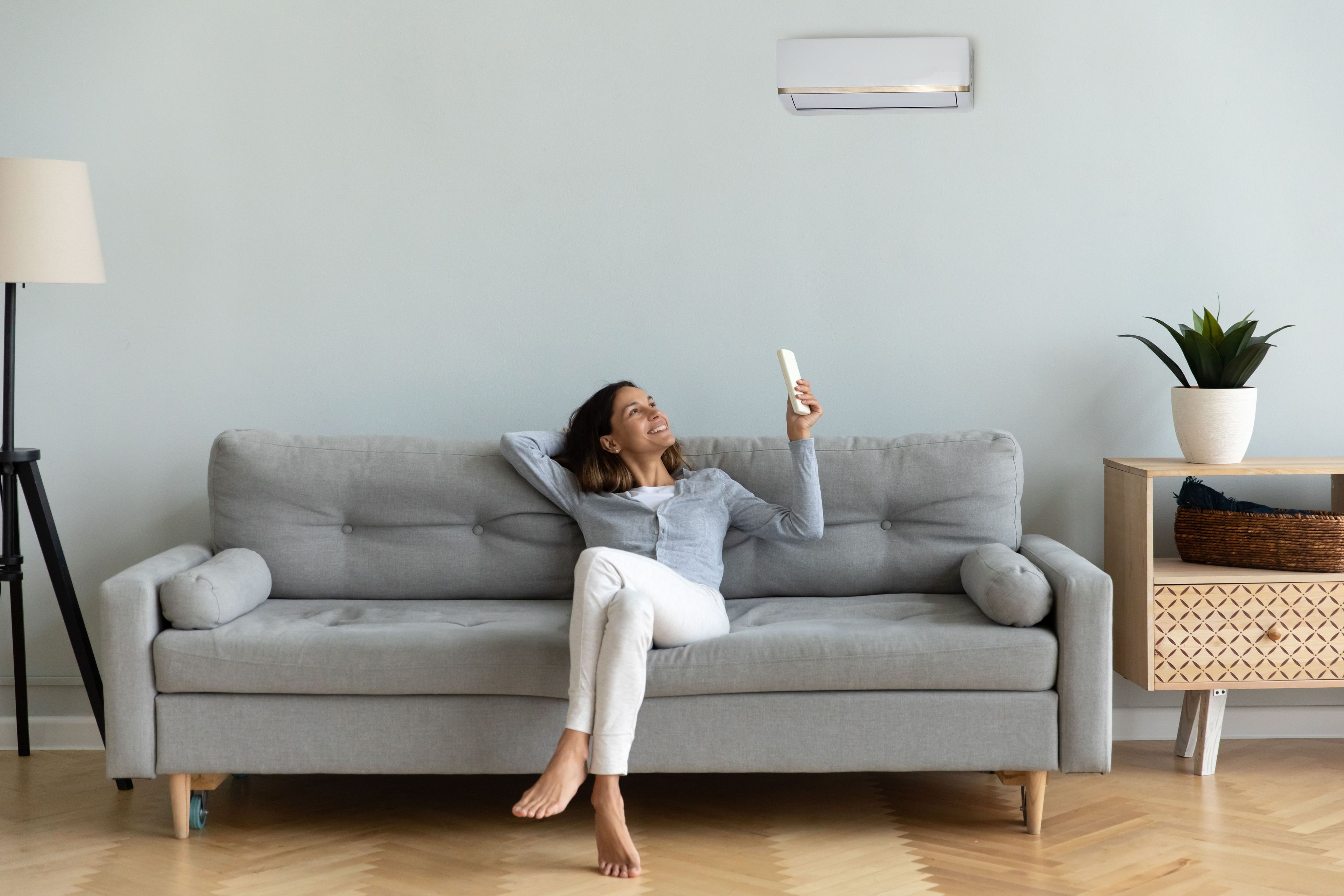 Una mujer usando el aire acondicionado en casa