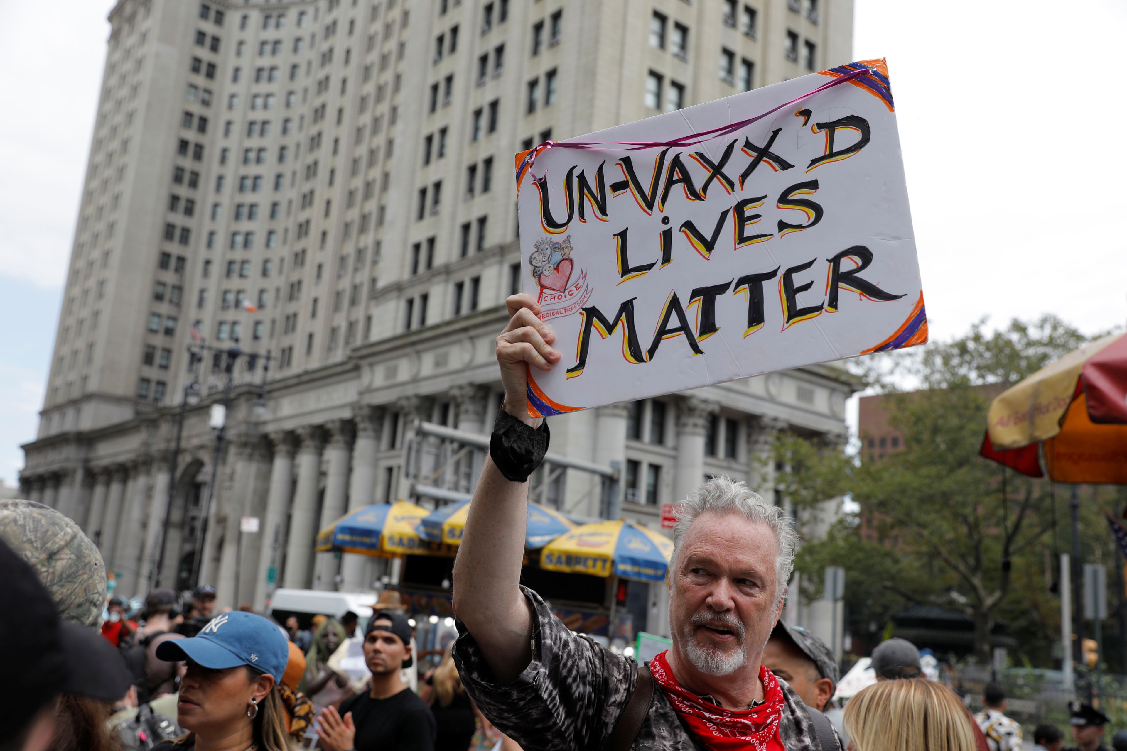Una manifestante sostiene un cartel durante una protesta contra la vacuna del COVID-19 celebrada frente al Ayuntamiento de Nueva York, Estados Unidos, el 9 de agosto de 2021.