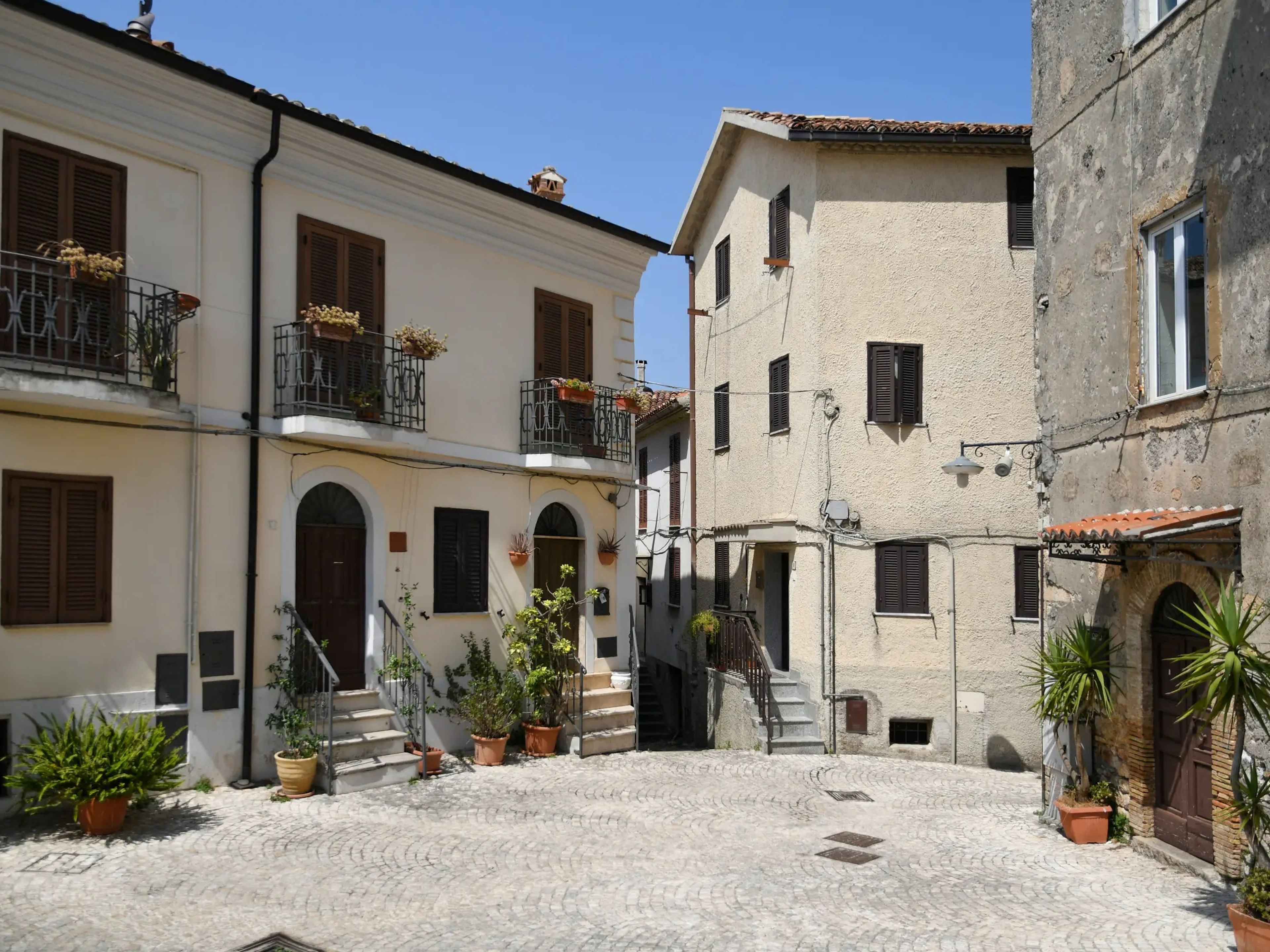 A small, empty street in Maenza, a medieval village in the Lazio region. Blue skies.
