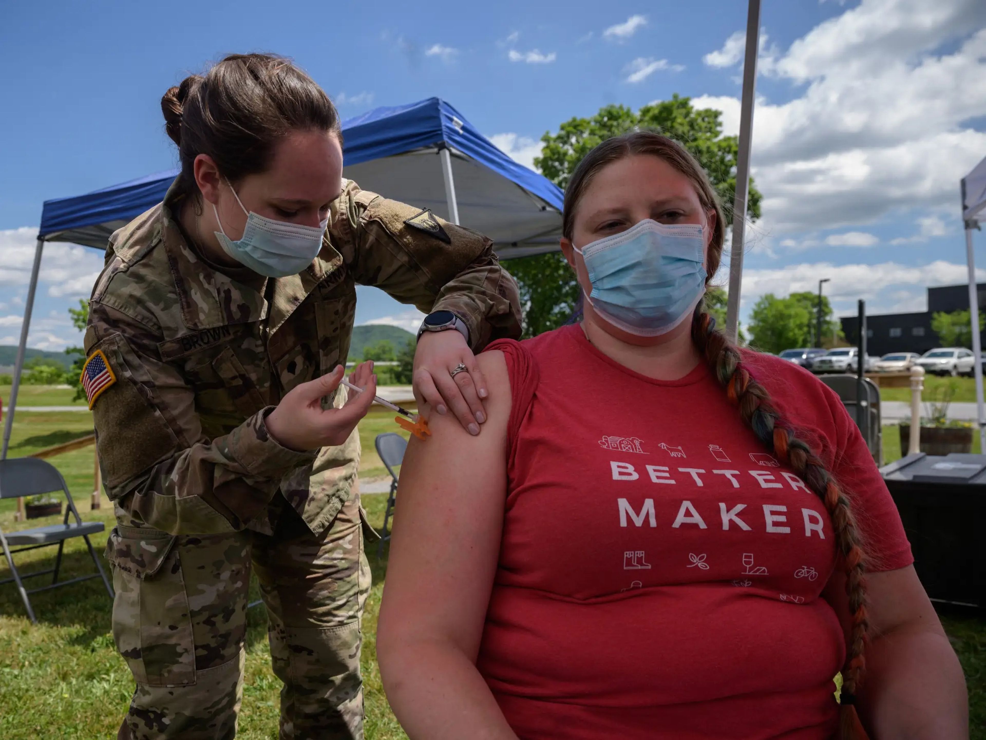 Una soldado vacuna a una mujer contra el COVID-19.