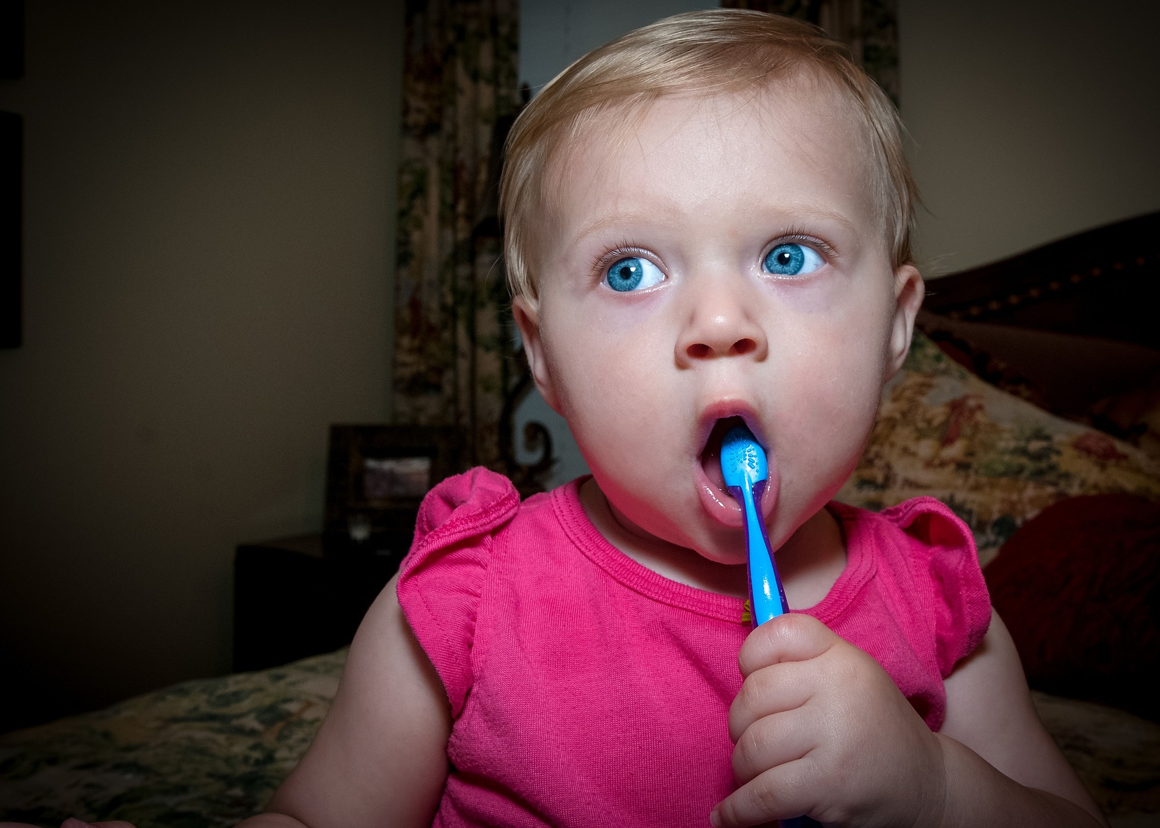 Un bebé con un cepillo de dientes en la boca.