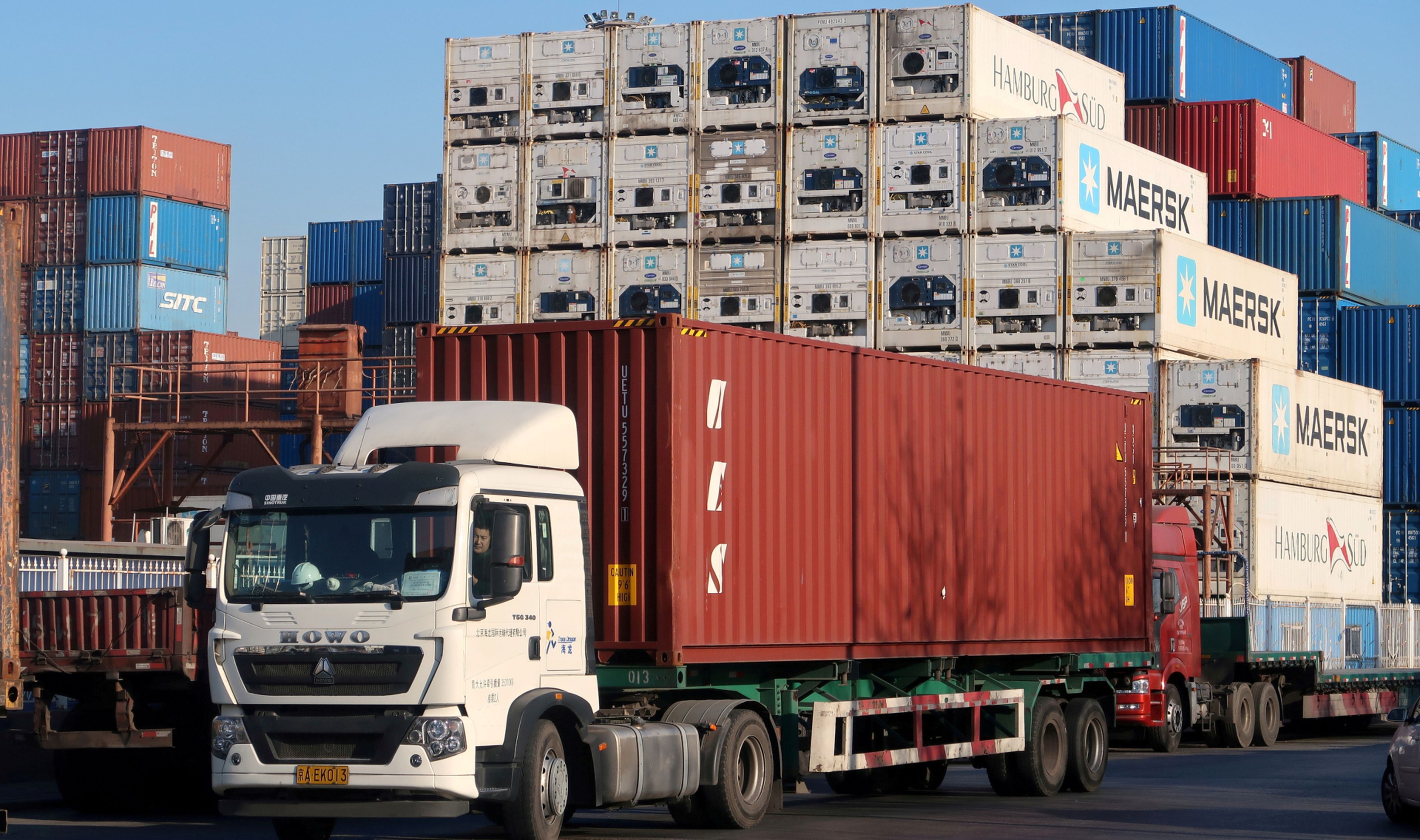 Un camión transporta un contenedor logístico en el puerto de Tianjin (China)
