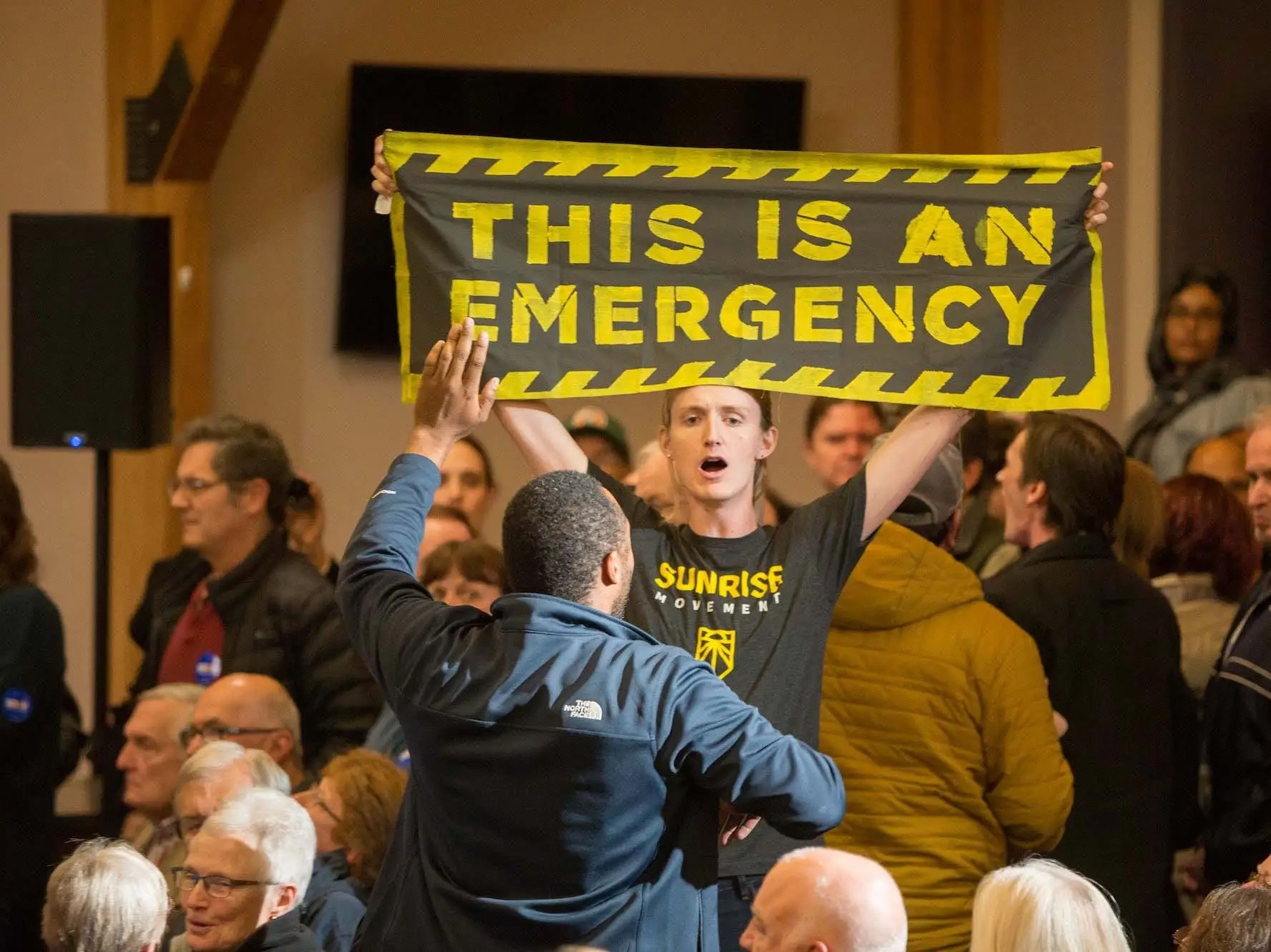 Manifestantes contra la emergencia climática interrumpen al entonces candidato Joe Biden durante un evento de campaña en New Hampshire en 2019. El Movimiento Sunrise se autodenomina un movimiento juvenil centrado en prevenir el cambio climático.