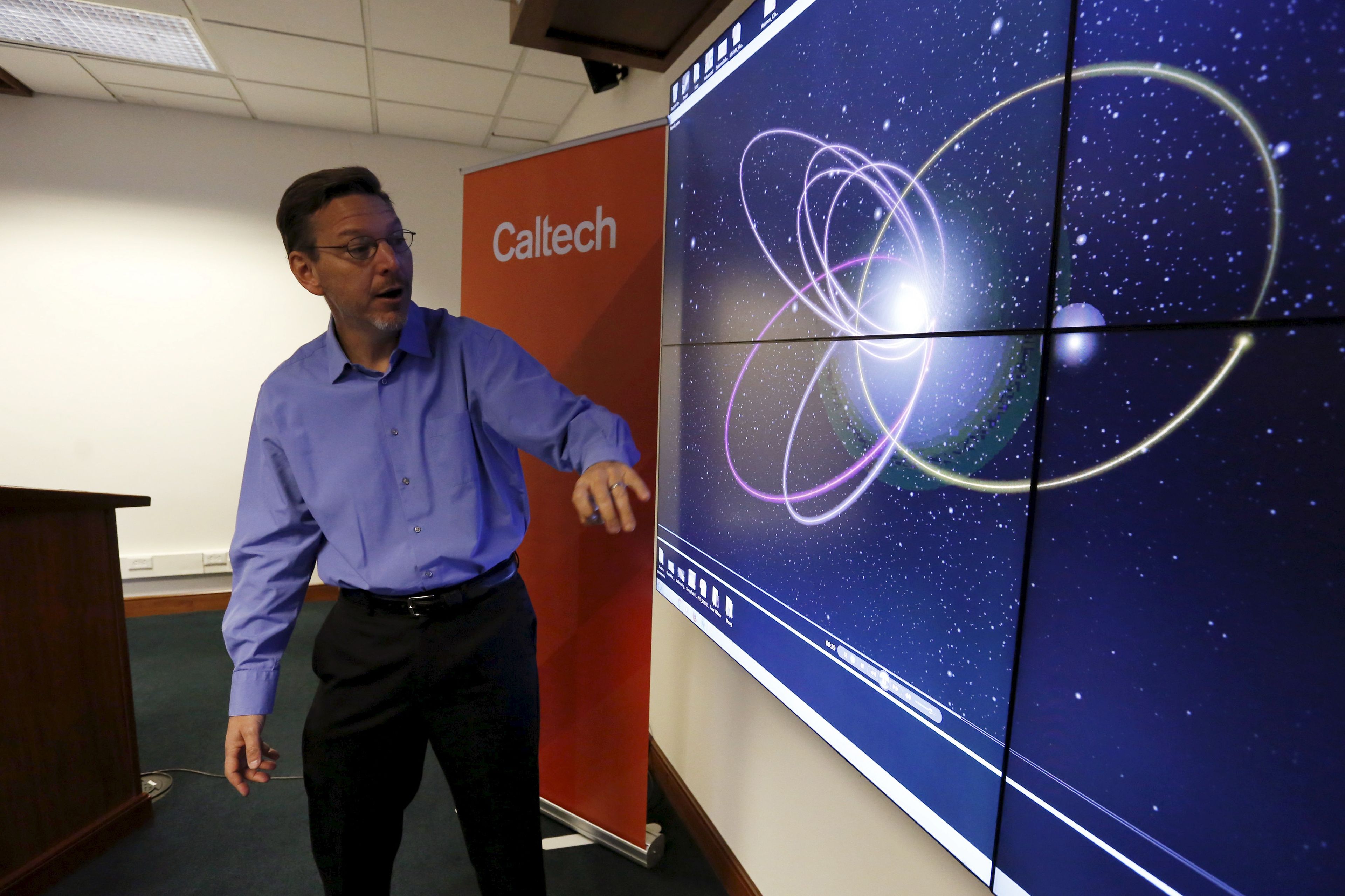 Mike Brown habla sobre la posible órbita del Planeta 9, frente a una simulación por ordenador, el 20 de enero de 2016.