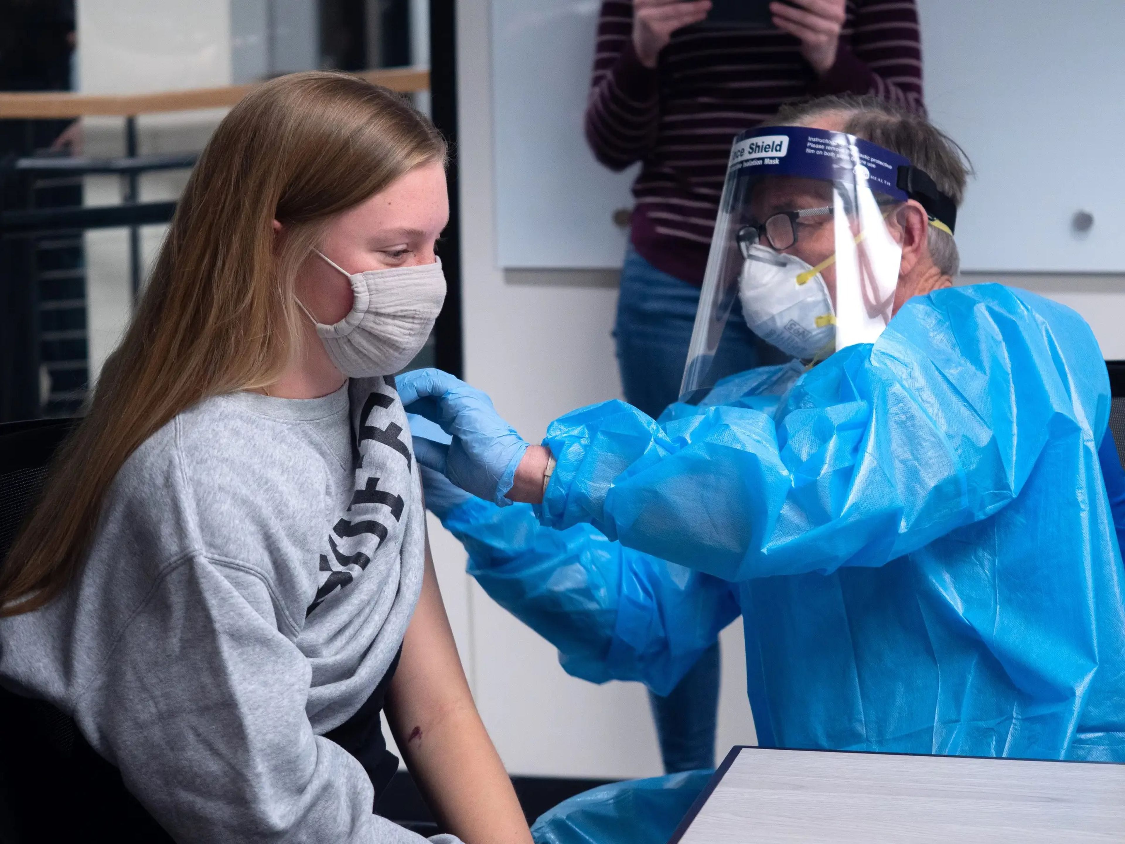 Olivia Parsons, 22, estudiante de neurociencia en la Universidad de Colorado Boulder, a la izquierda, recibe su primera dosis de la vacuna de Moderna la doctora Laird Wolve.