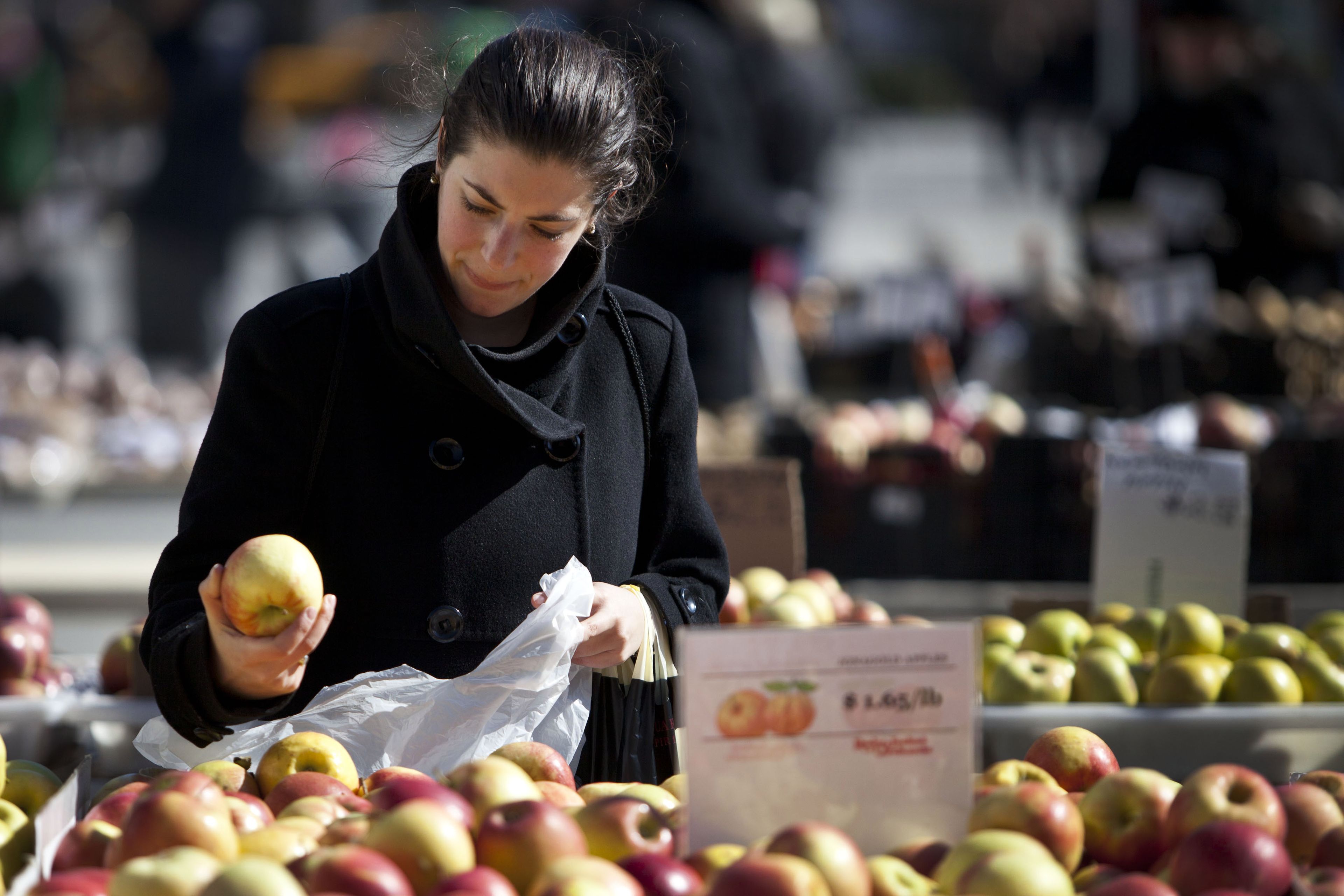 mujer comprando manzanas