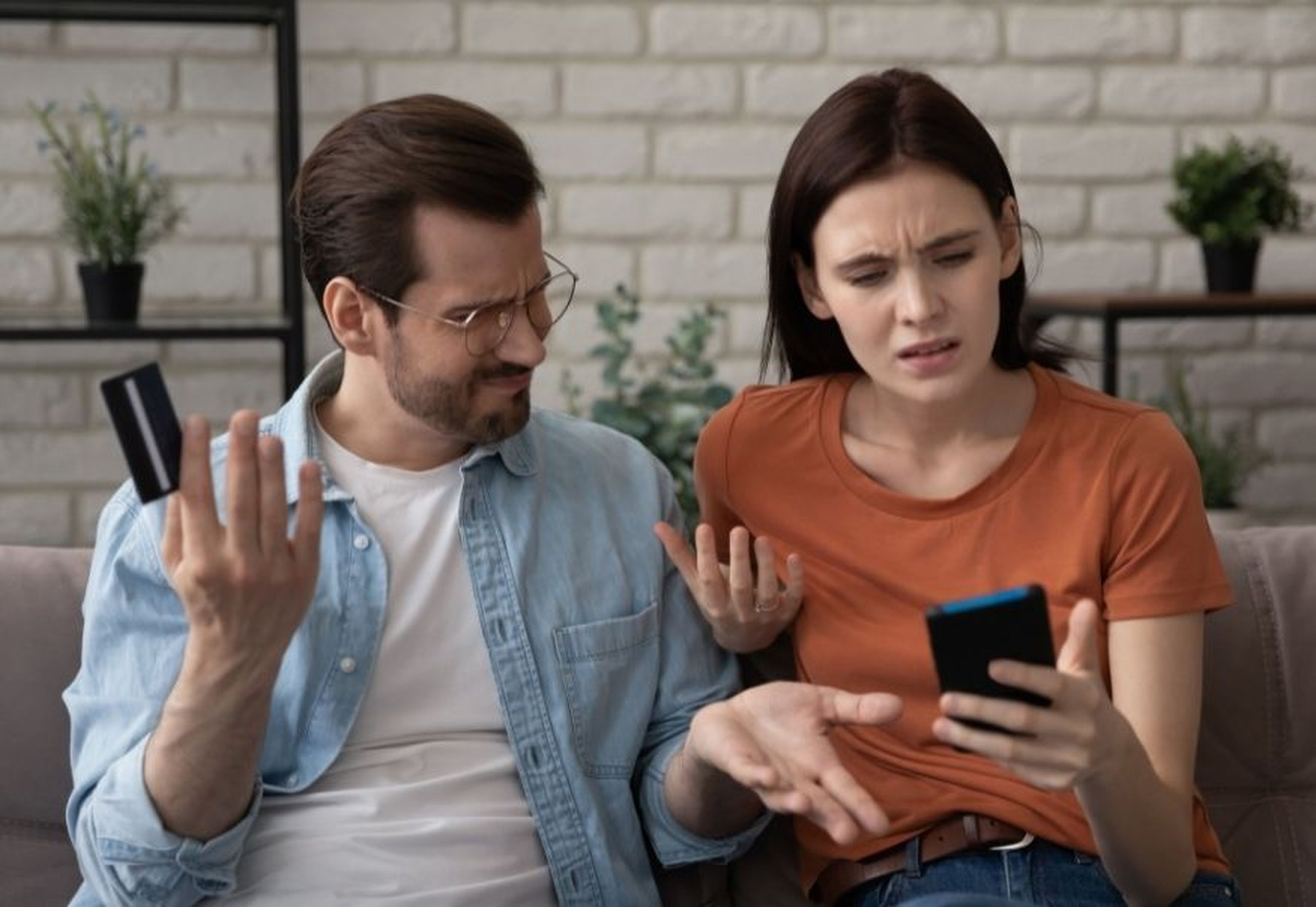 Una pareja mira el móvil con preocupación.