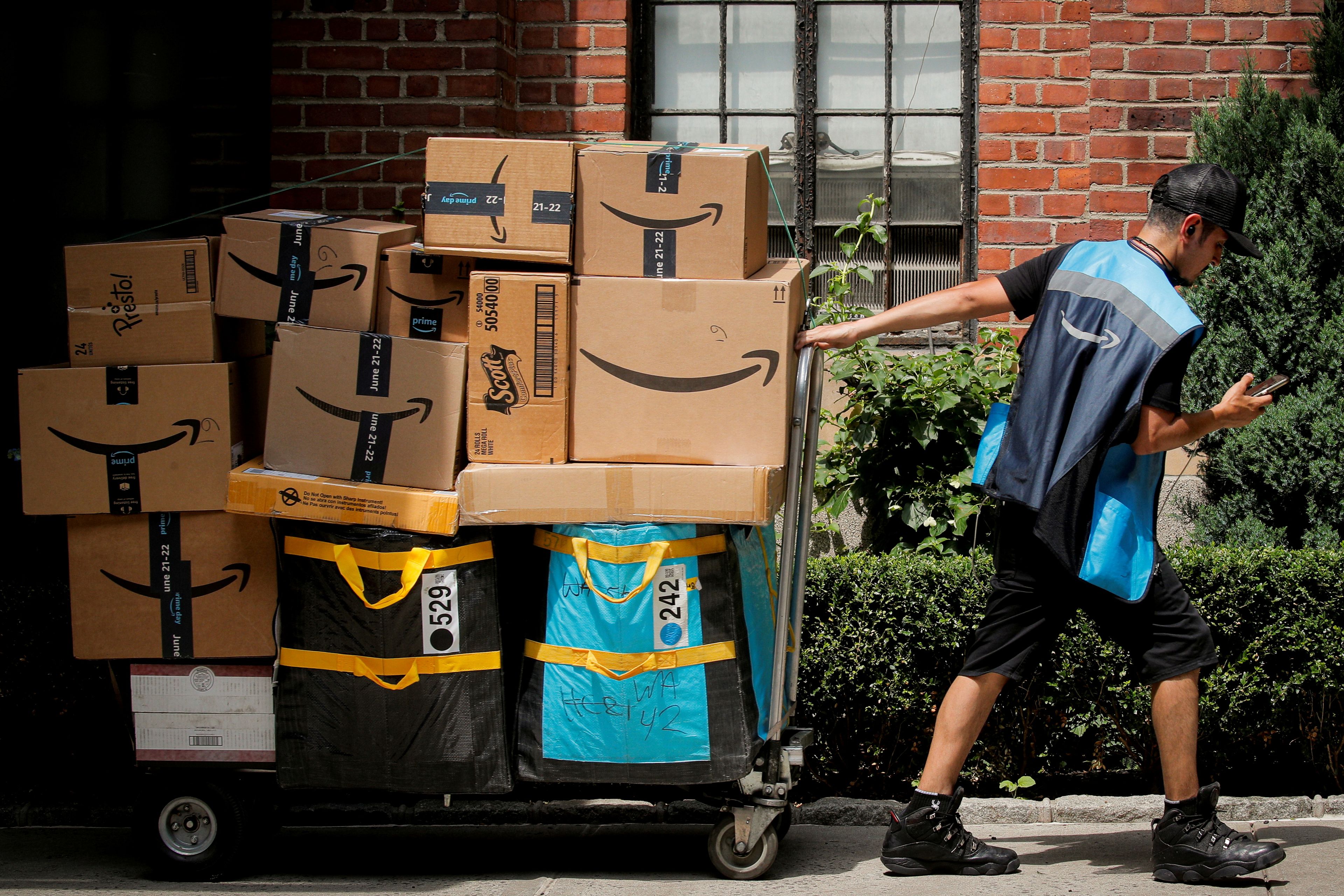 Un trabajador de Amazon transportando un cargamento de envíos