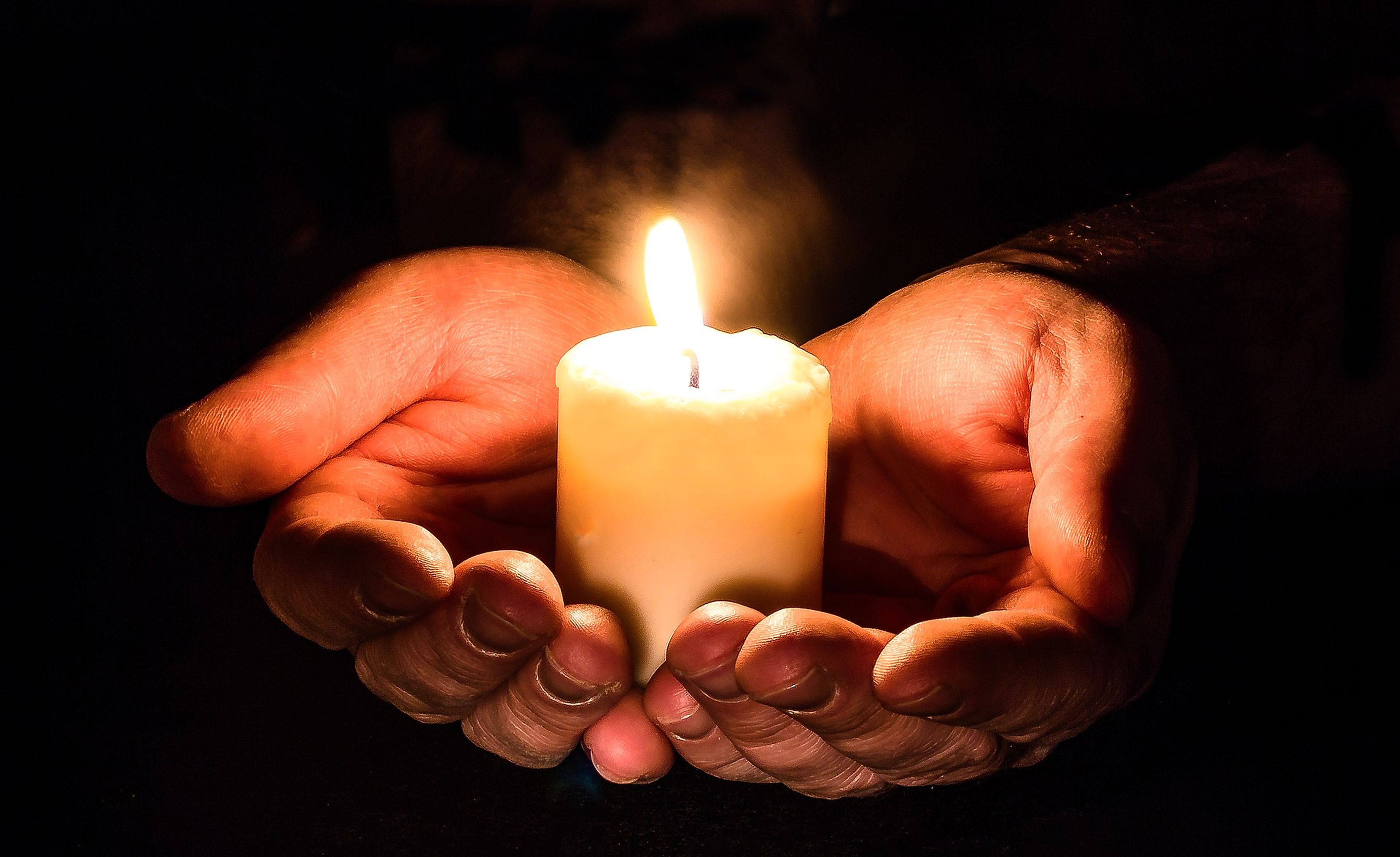 Unas manos sujetan una vela.