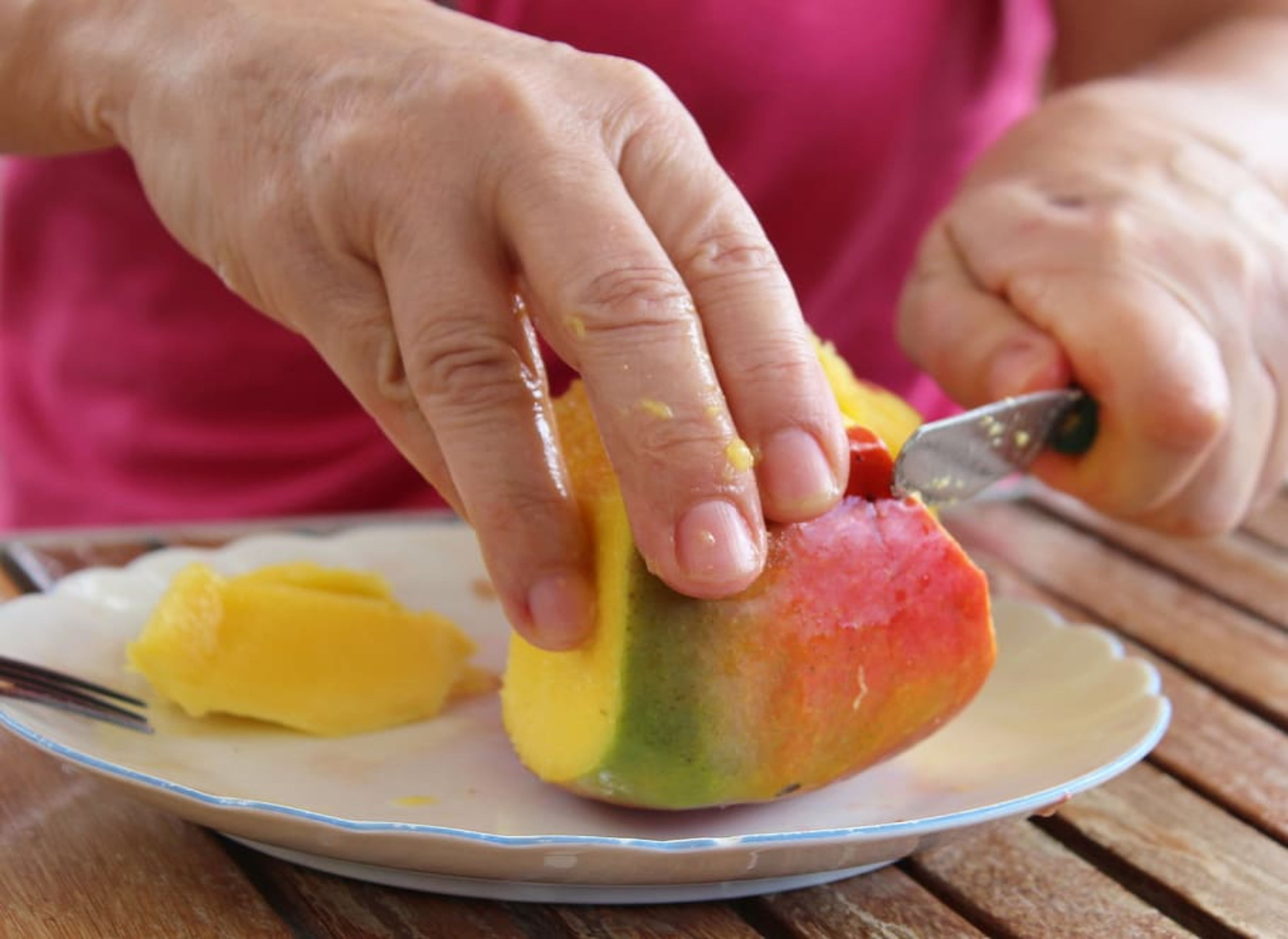 Un hombre cortando mango