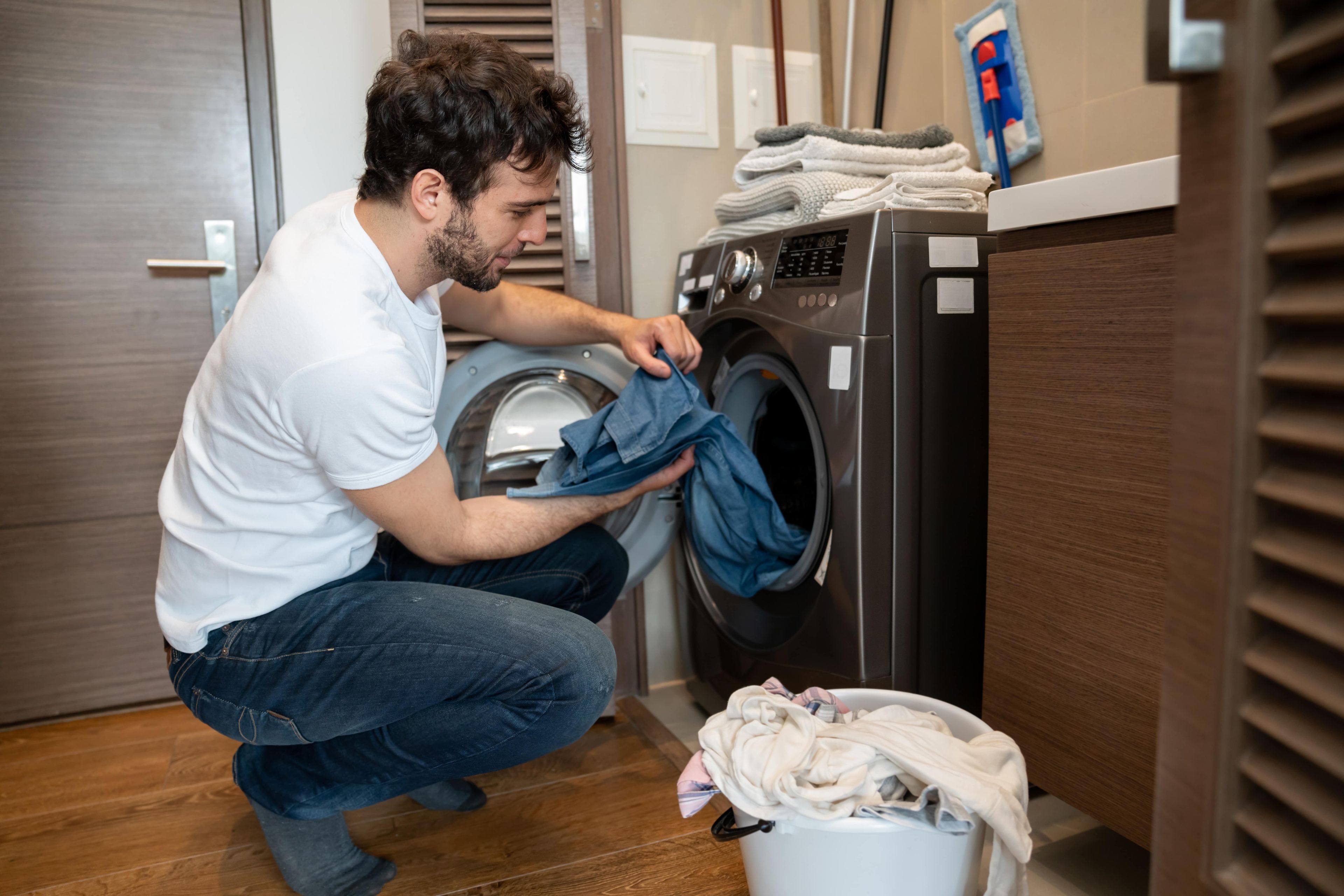 Un hombre sacando ropa de la lavadora