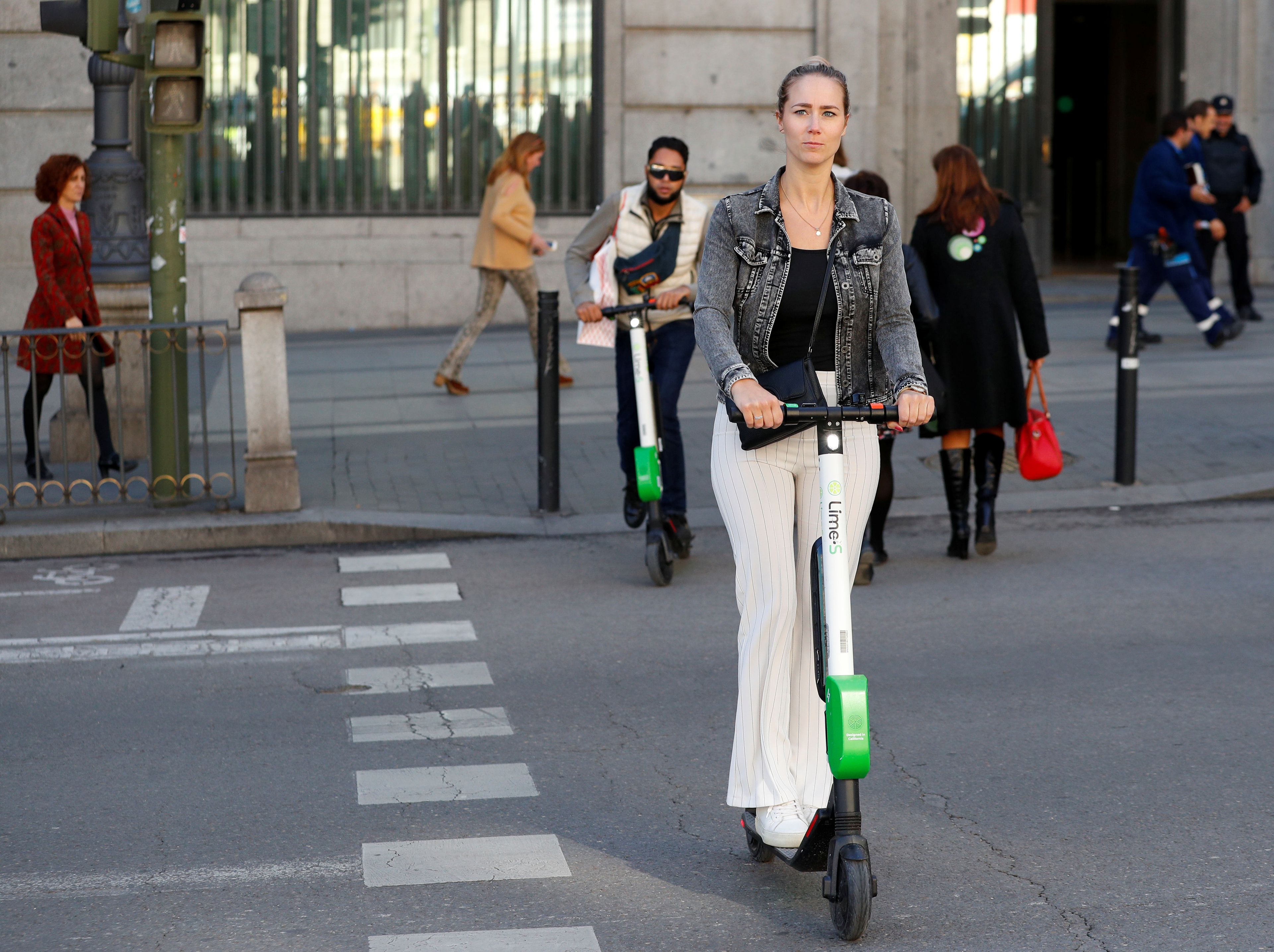 Una mujer con patinete eléctrico en Madrid