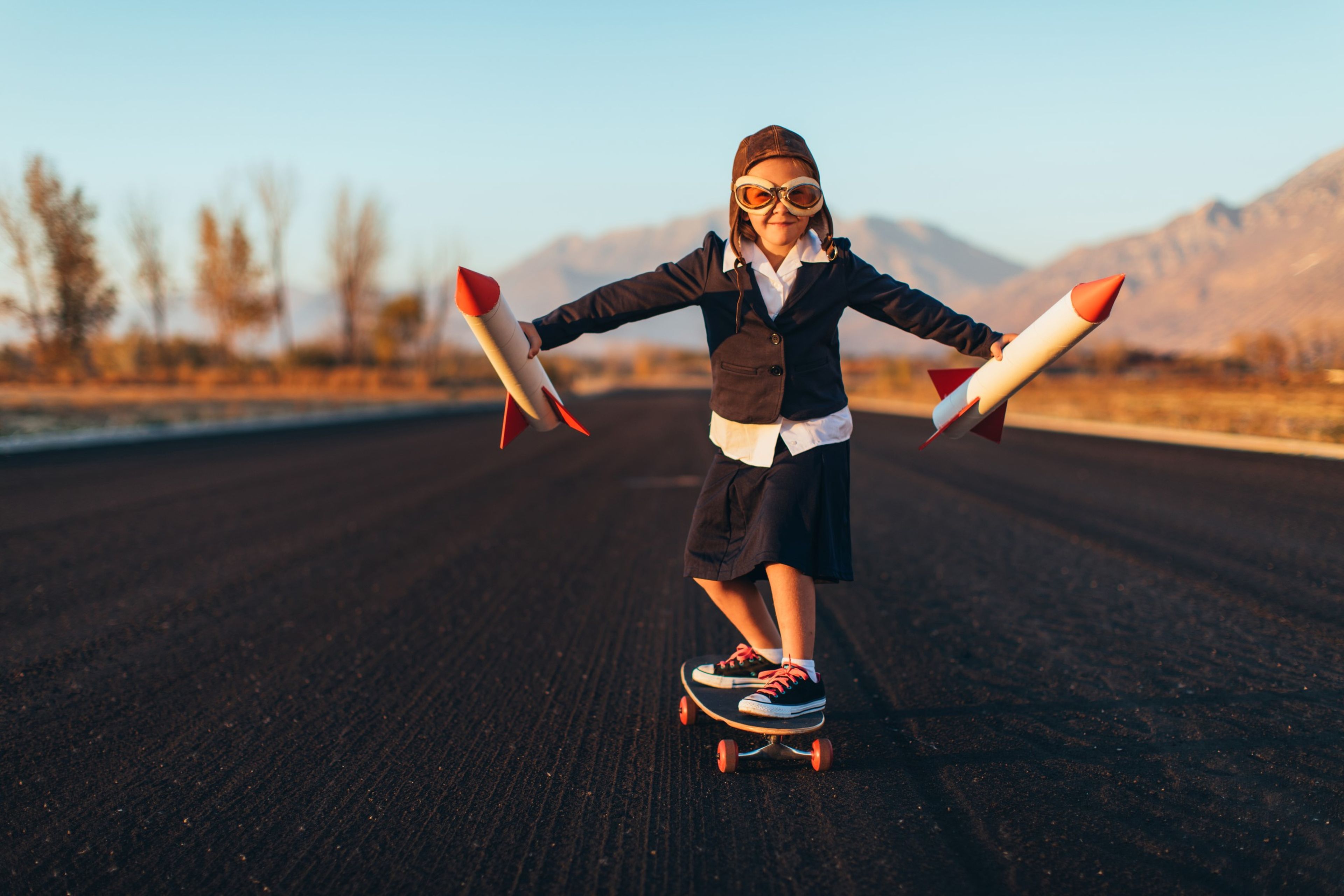 Una niña monta en patinete en una pista de aviones