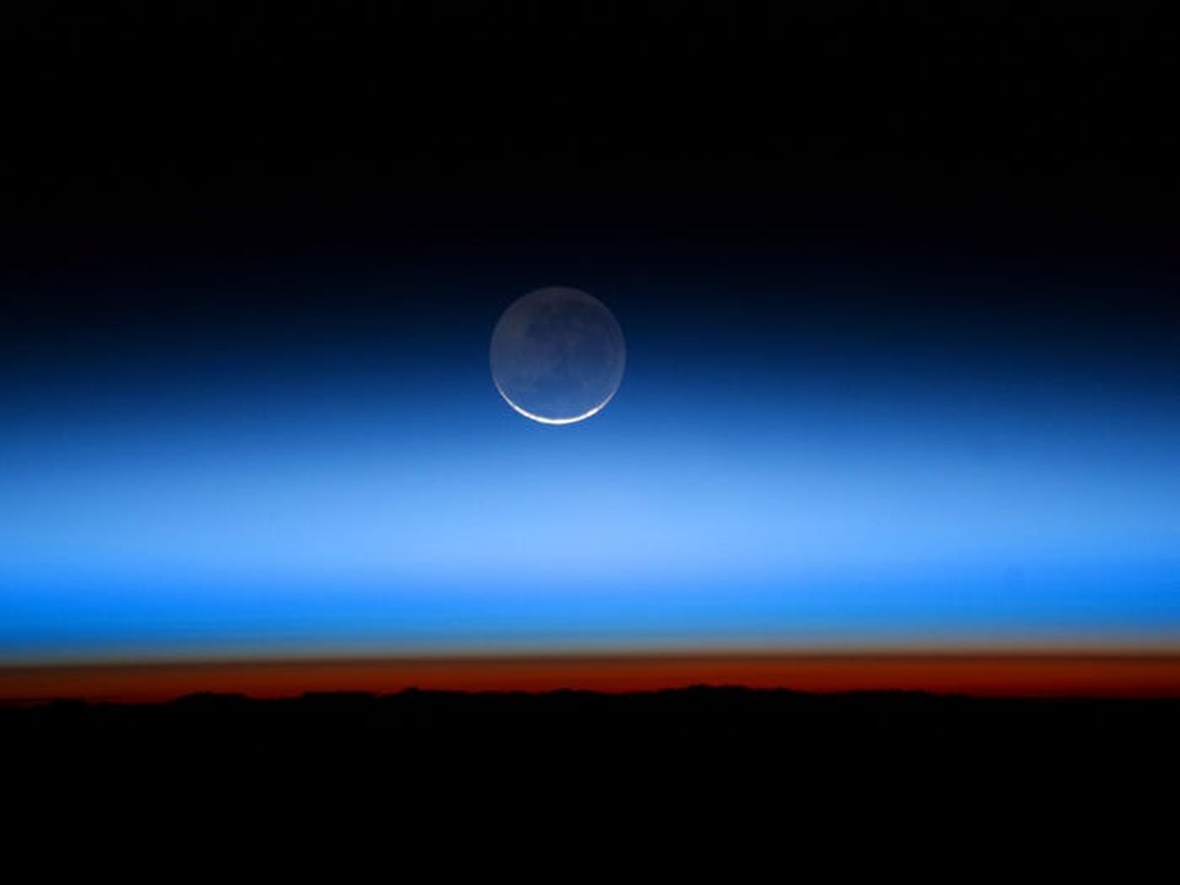 La luz de la Tierra en la Luna le da un tono azulado.