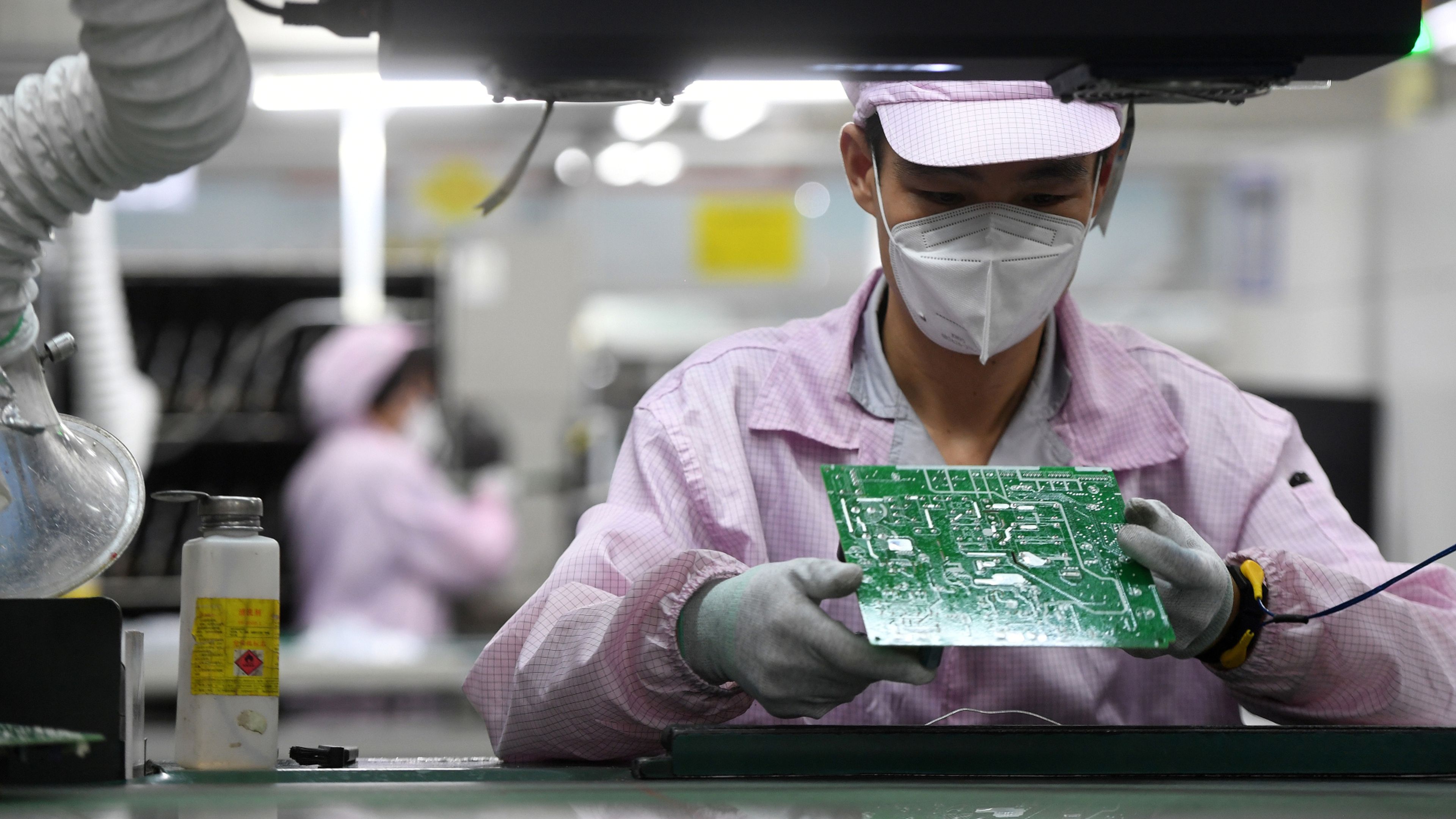 Un trabajador revisa una placa base en una fábrica de Gree en China