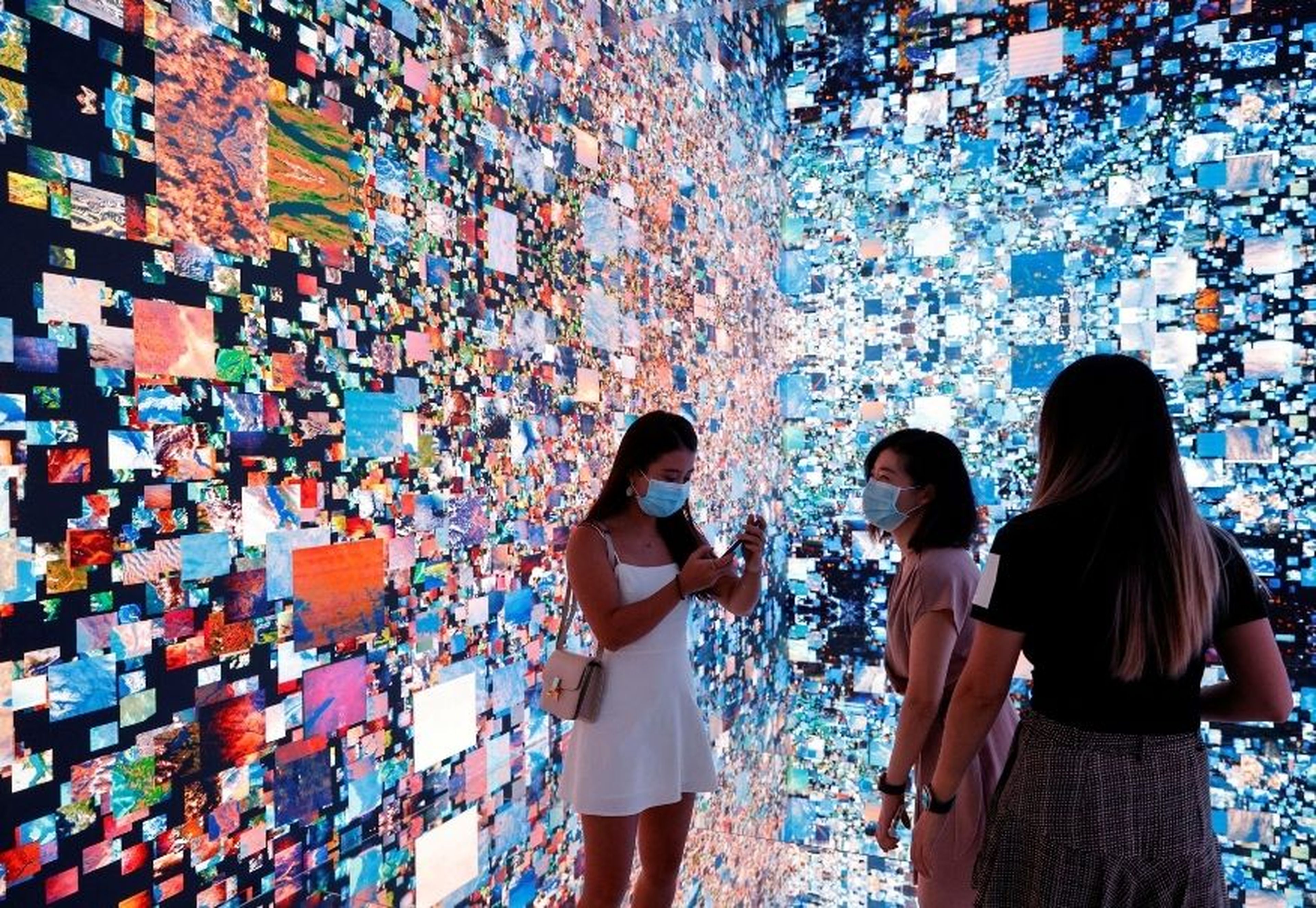 Varias personas frente a una instalación de arte que se convirtió en NFT y se subastó online en Sotheby's, en Hong Kong.