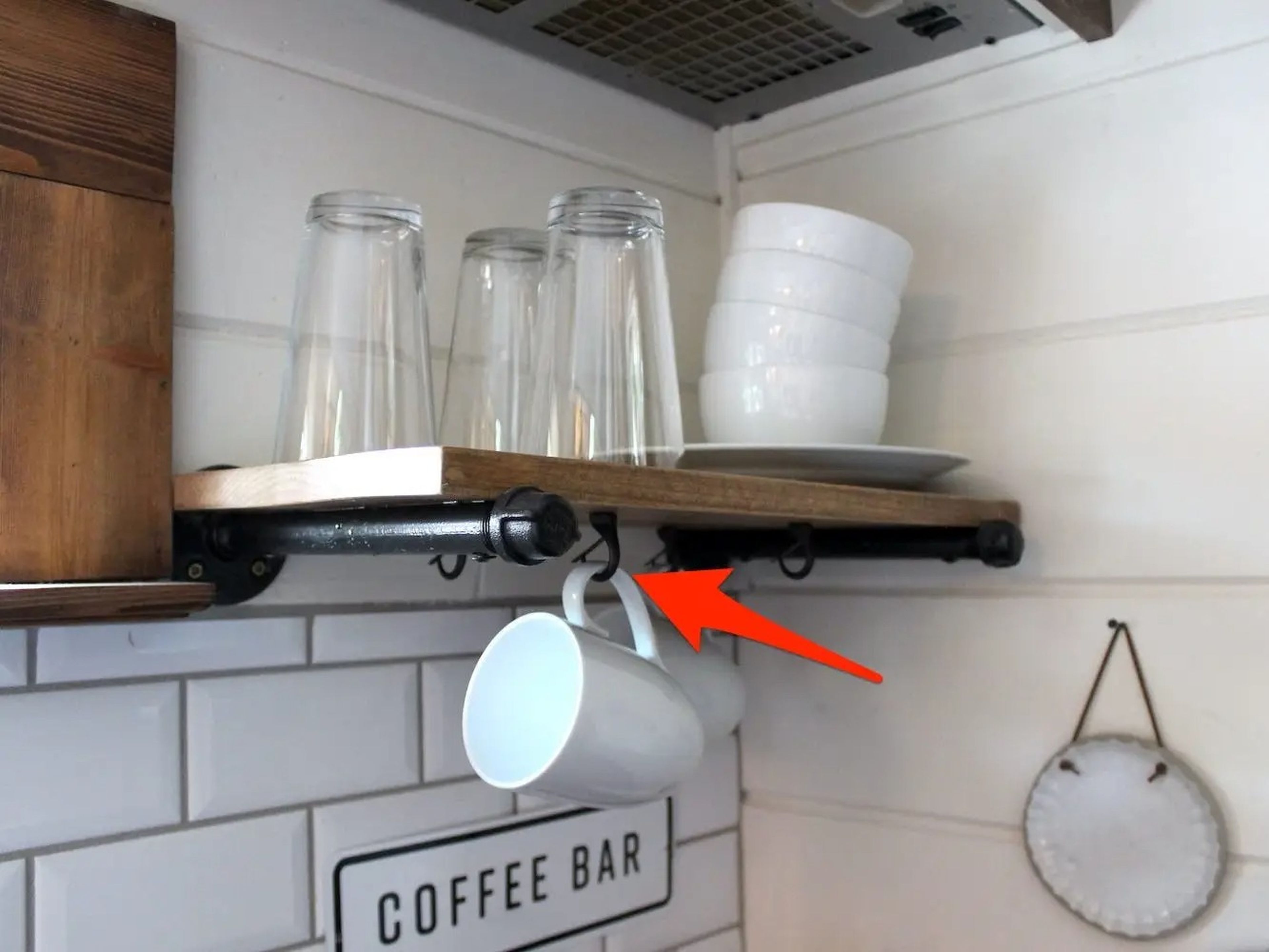La flecha apunta a los ganchos donde se cuelgan las tazas de café en la pequeña vivienda de WeeCasa.