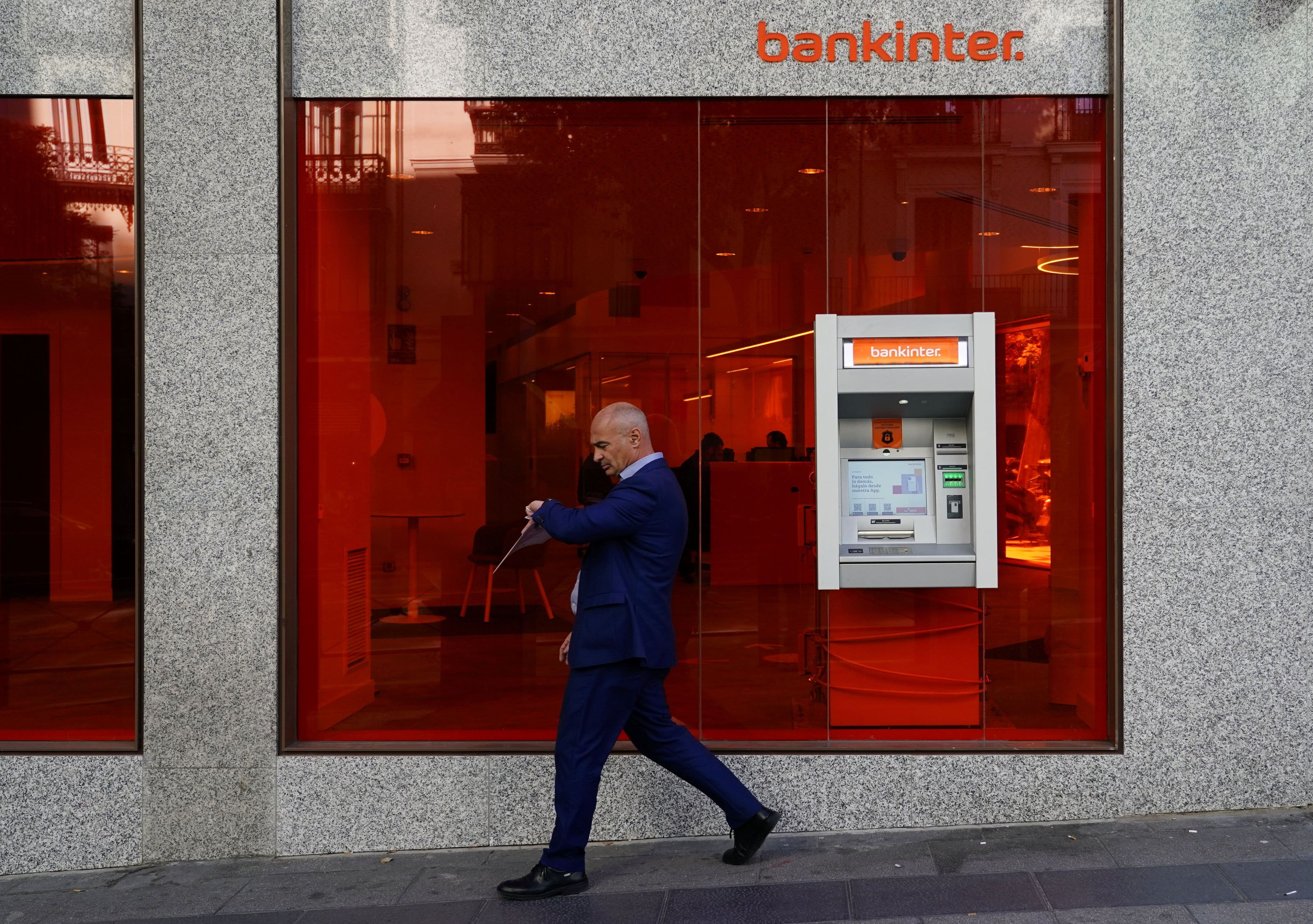 Un hombre camina junto a una oficina de Bankinter