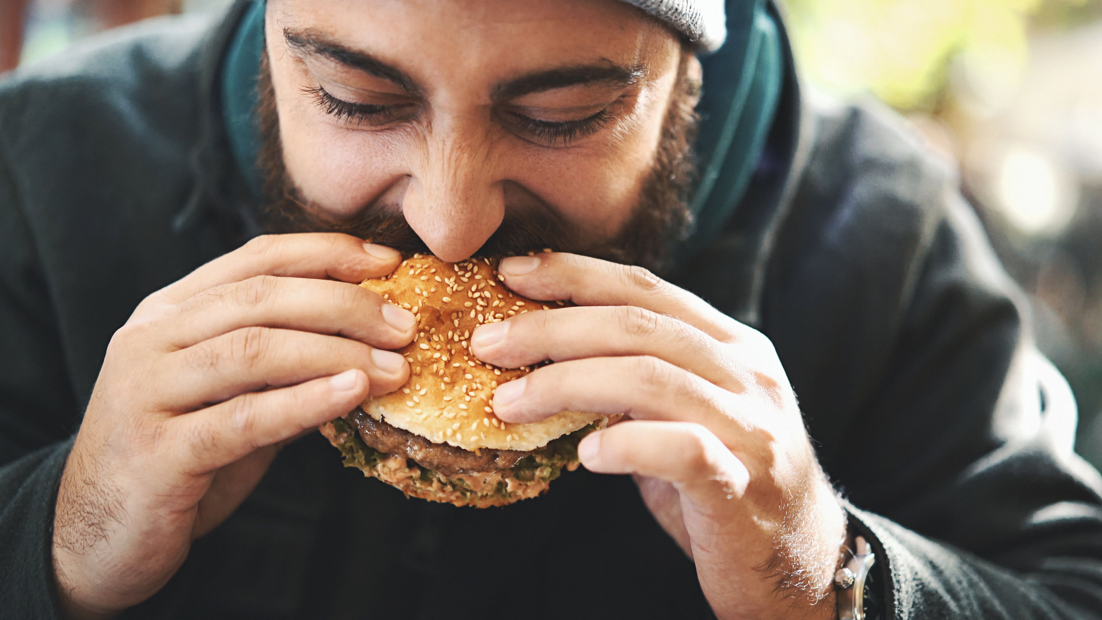 Un hombre comiendo una hamburguesa