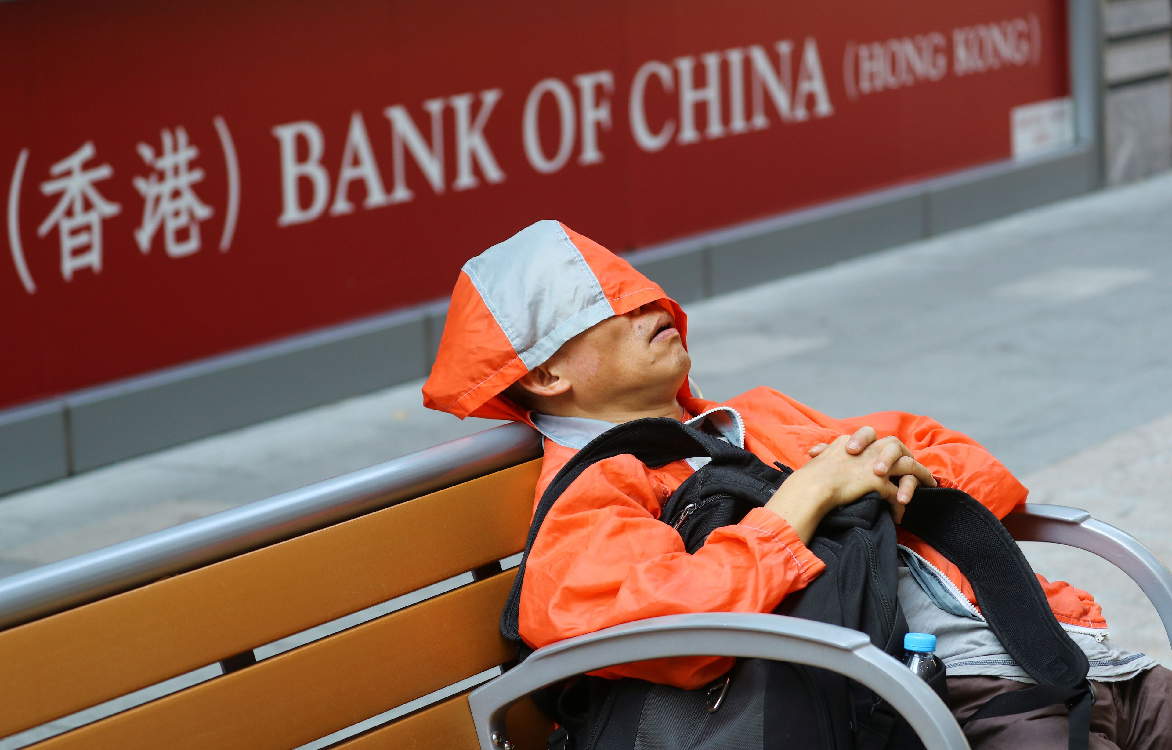 hombre duerme a las afueras del Banco de China