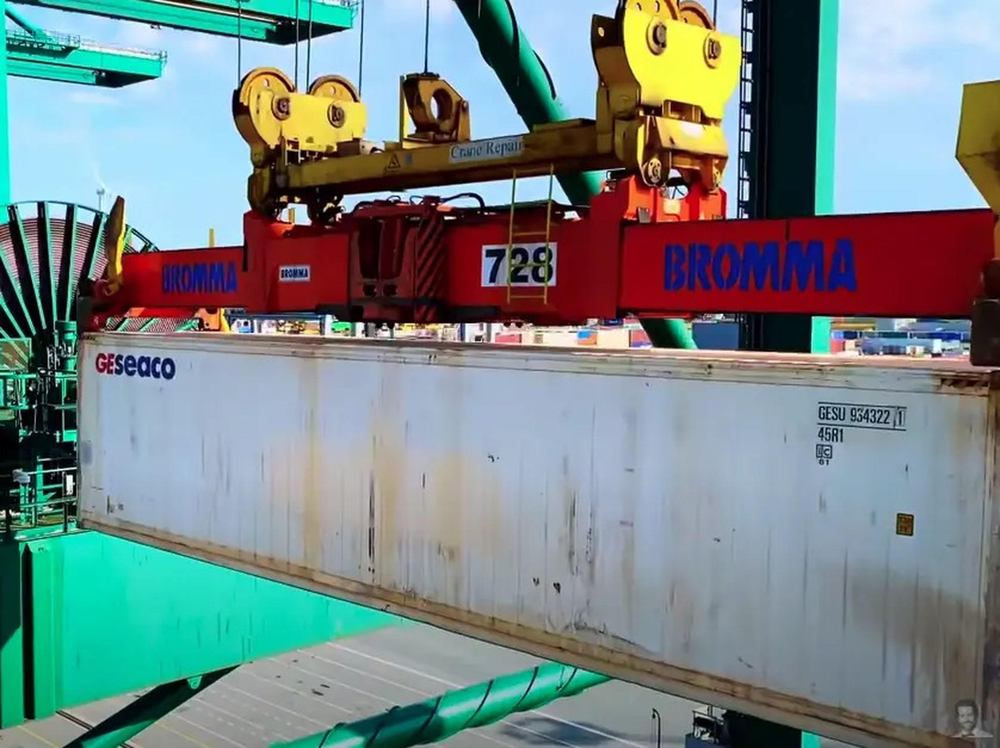 A crane takes 20-foot containers off the ship