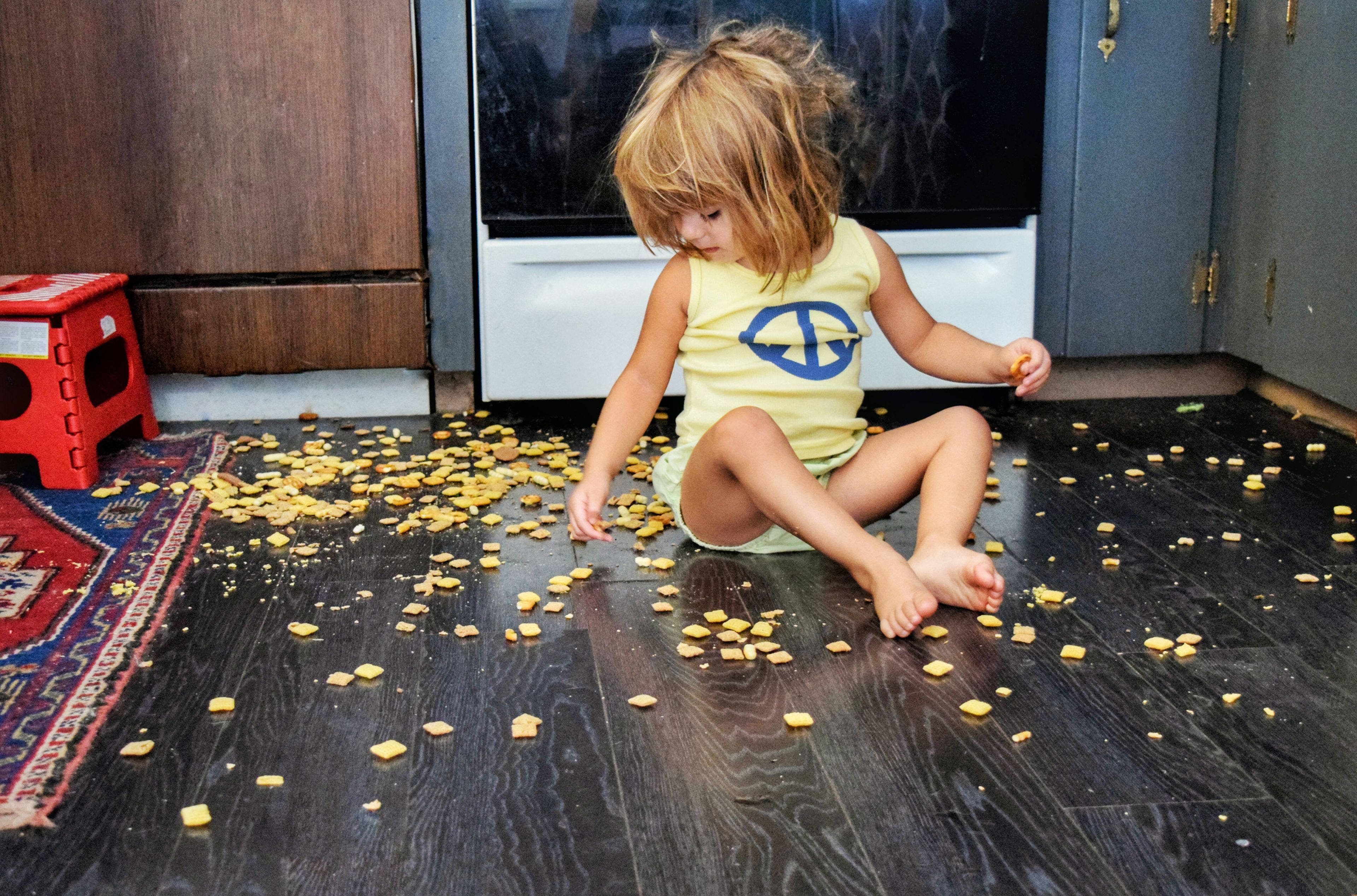 niña comiendo comida del suelo
