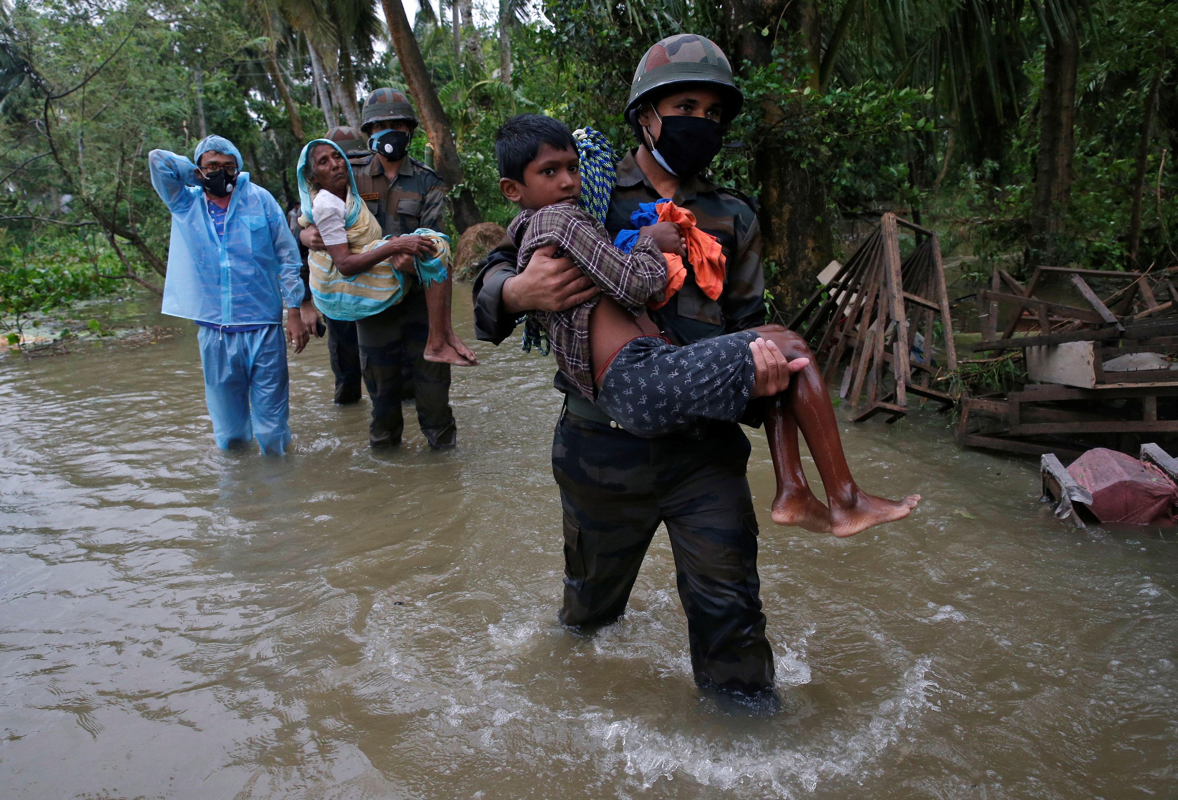 Un niño siendo rescatado de una inundación en la India.