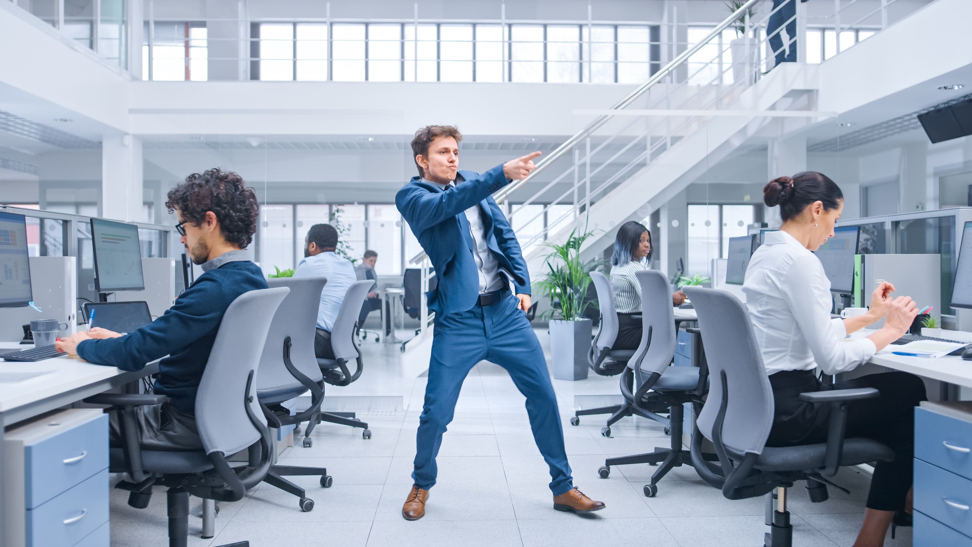 Una persona baila en medio de una oficina.