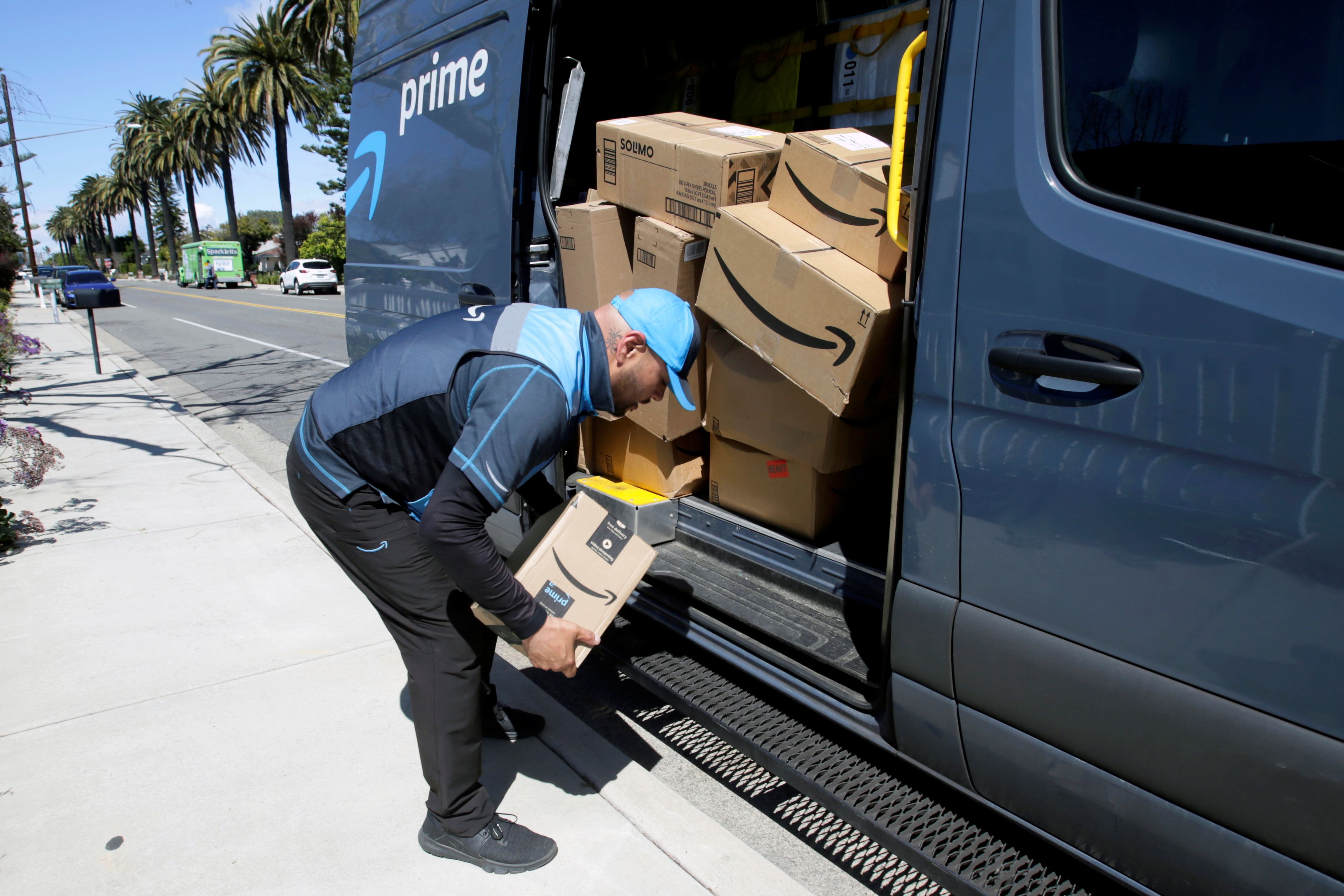 Repartidor de Amazon cargando paquetes en una furgoneta.