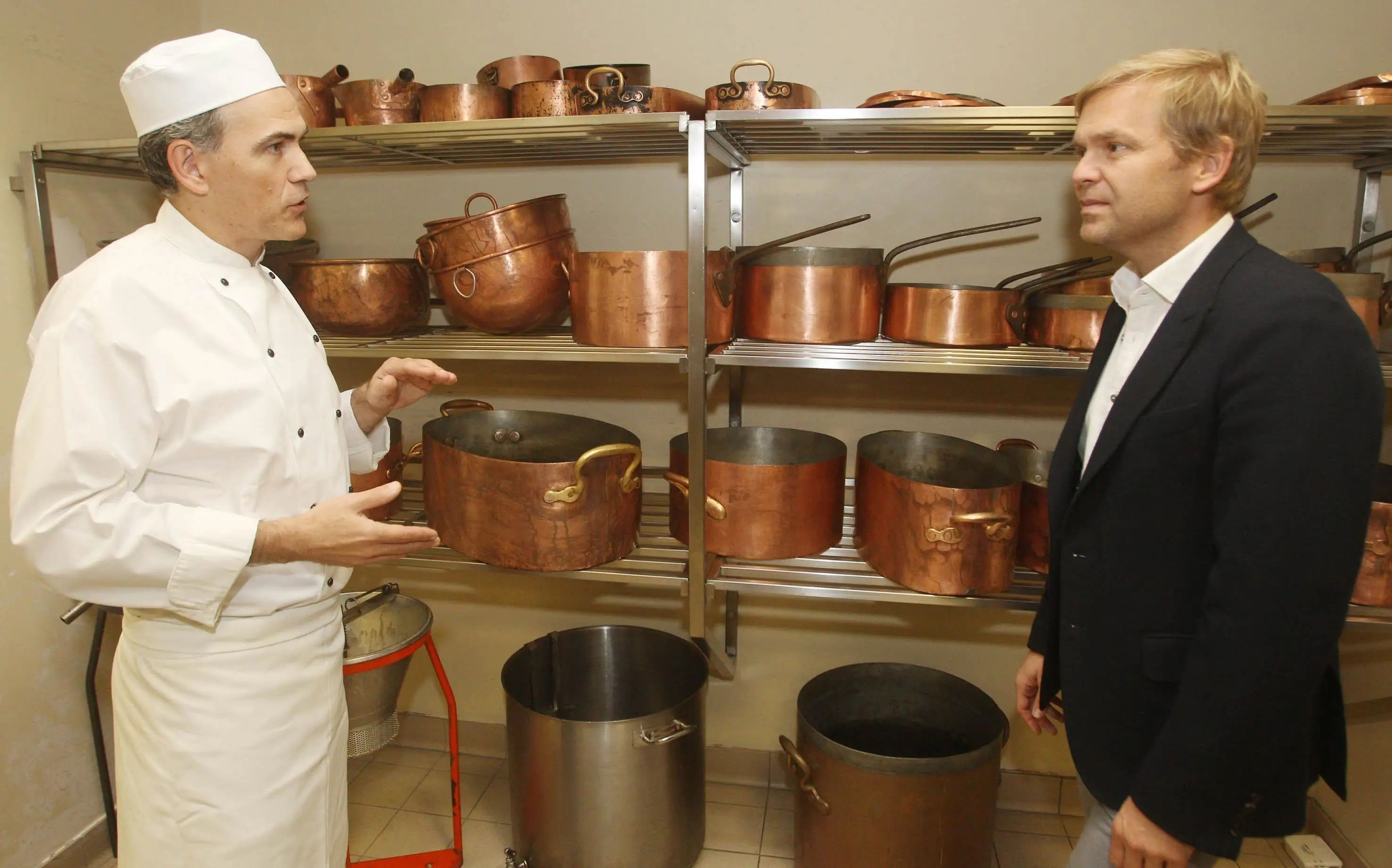 El chef real Mark Flanagan muestra al restaurador Bill Granger en las cocinas del Palacio de Buckingham en 2011.